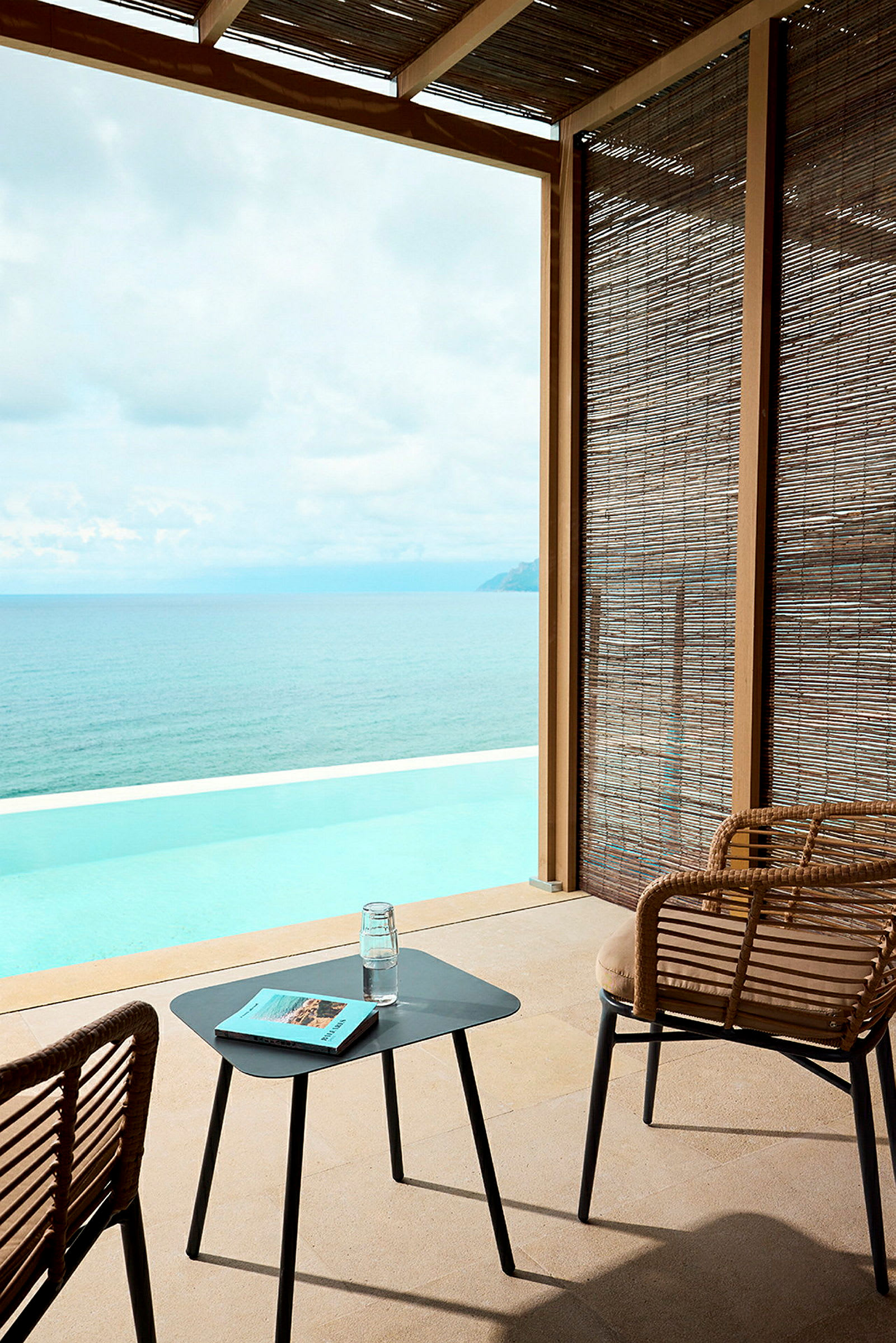 En siddegruppe med udsigt over en infinitypool og havet. (AI-genereret tekst)