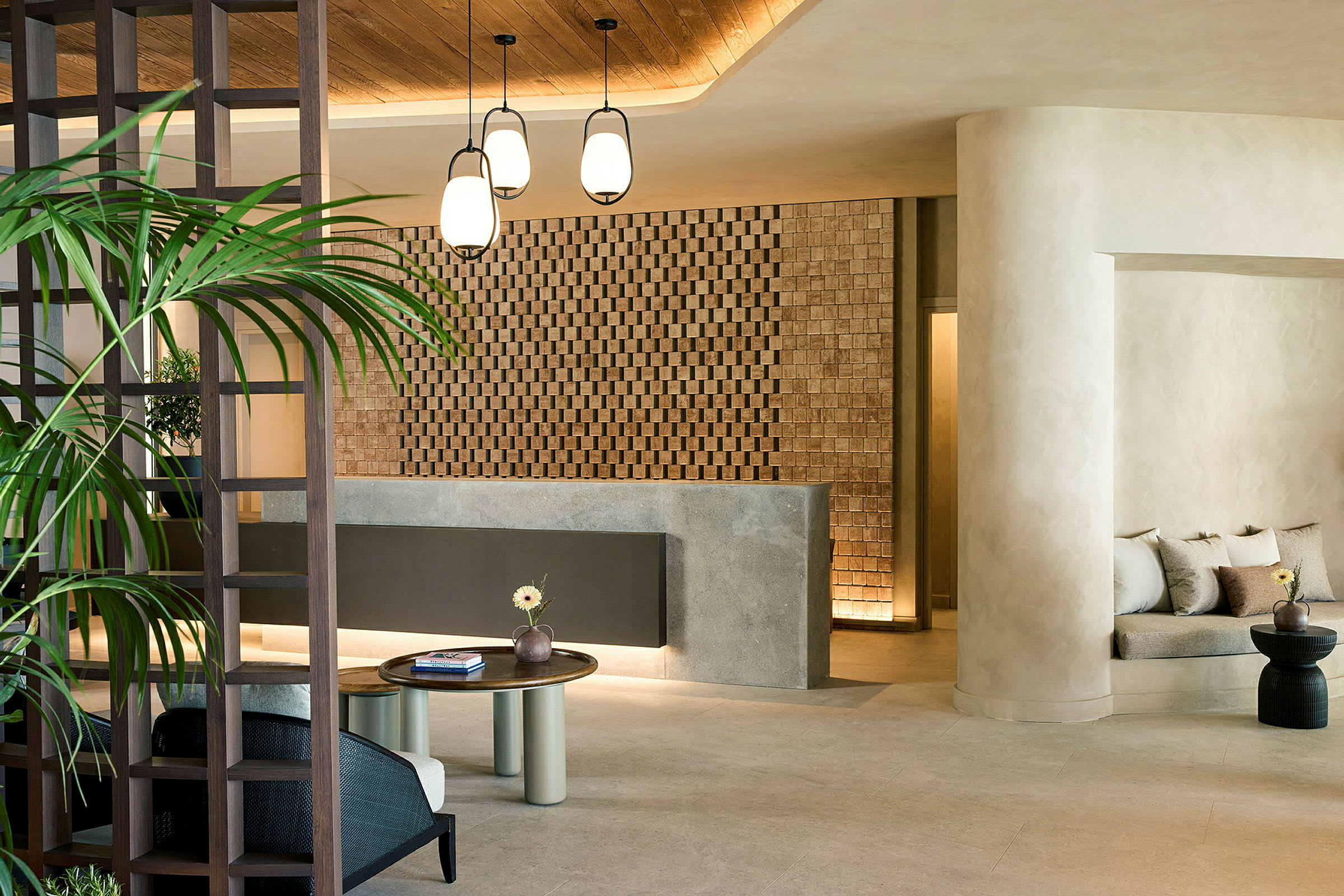 Hotellets lobby med reception, siddeområde og dekorativ væg. (AI-genereret tekst)