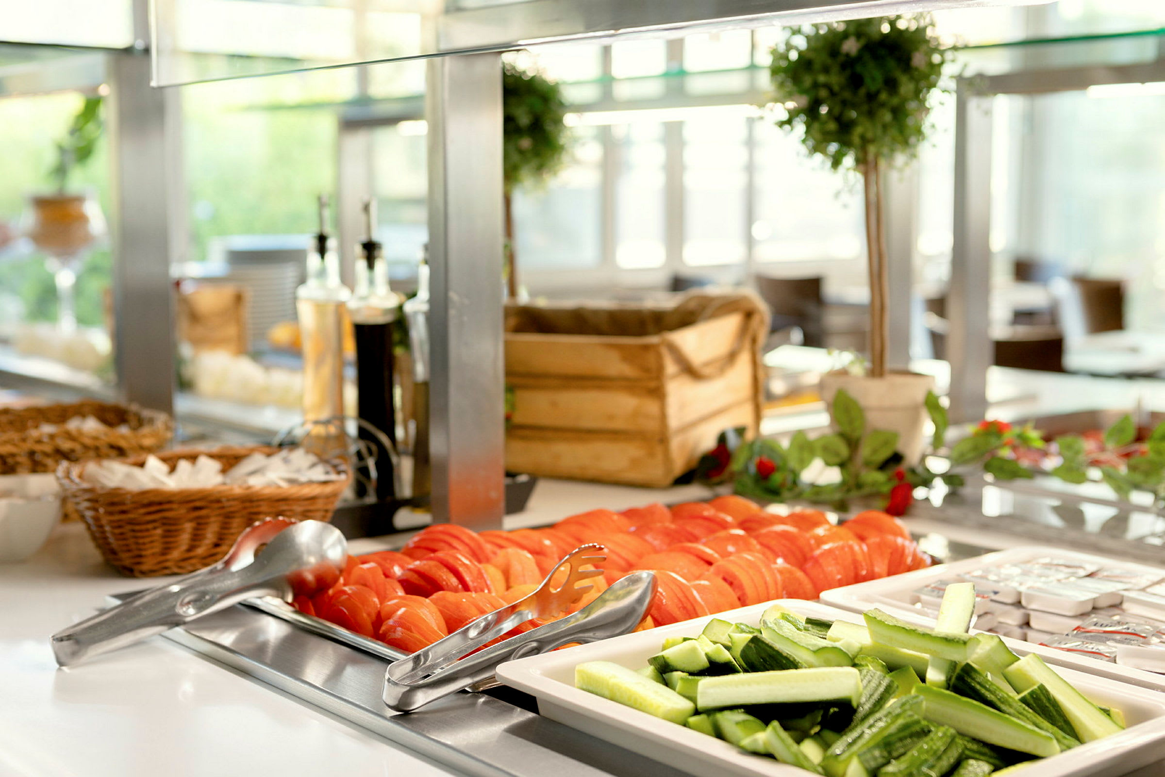 Billede der viser en buffet med skivede tomater og agurker samt andre tilbehør. (AI-genereret tekst)