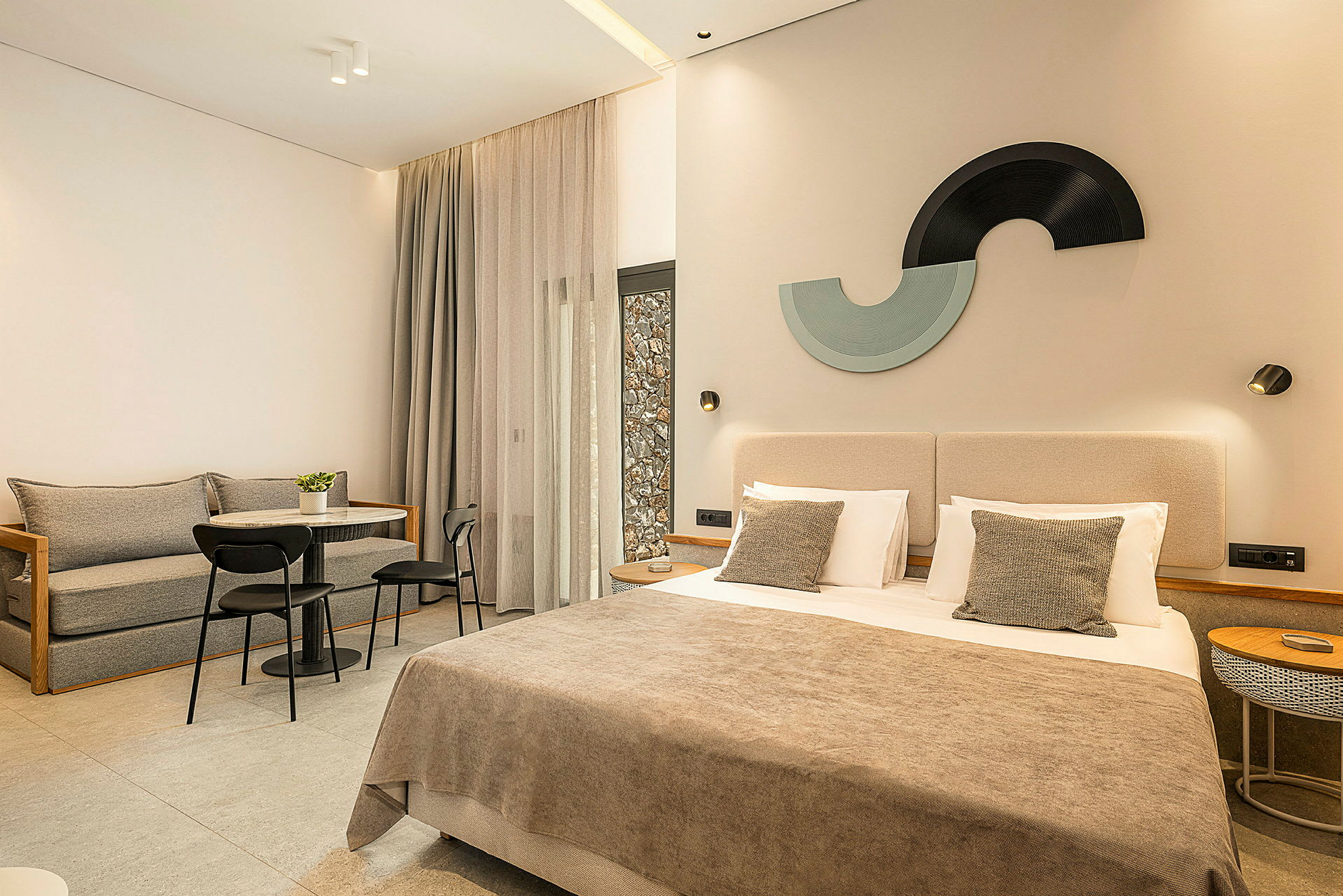 Moderne hotelværelse med en dobbeltseng, siddegruppe og dekorative detaljer. (AI-genereret tekst)