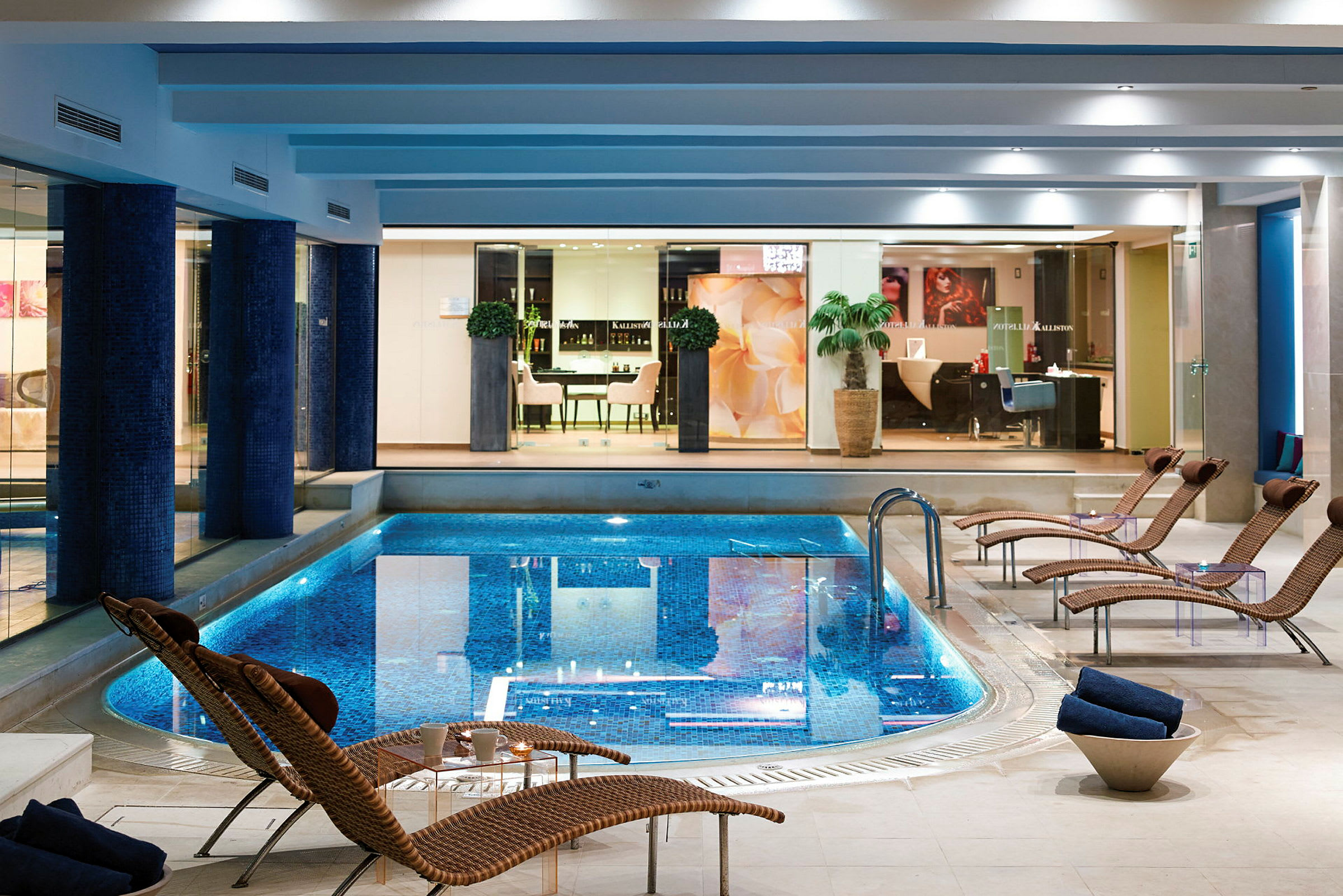 En indendørs pool i en elegant spa med liggestole omkring. (AI-genereret tekst)