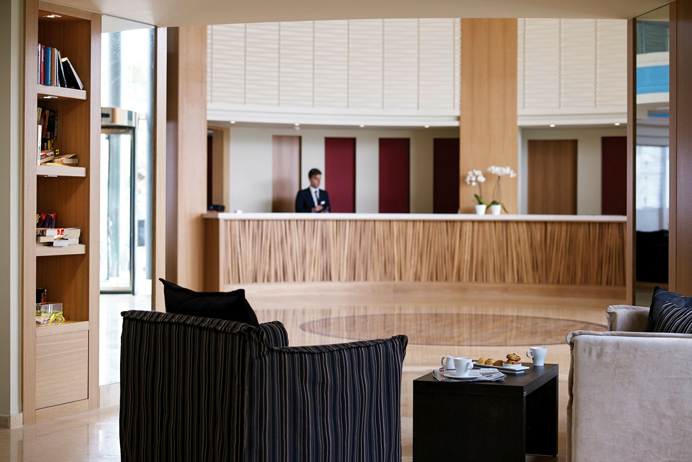Indgangsområde med reception, sofaer og borde. (AI-genereret tekst)