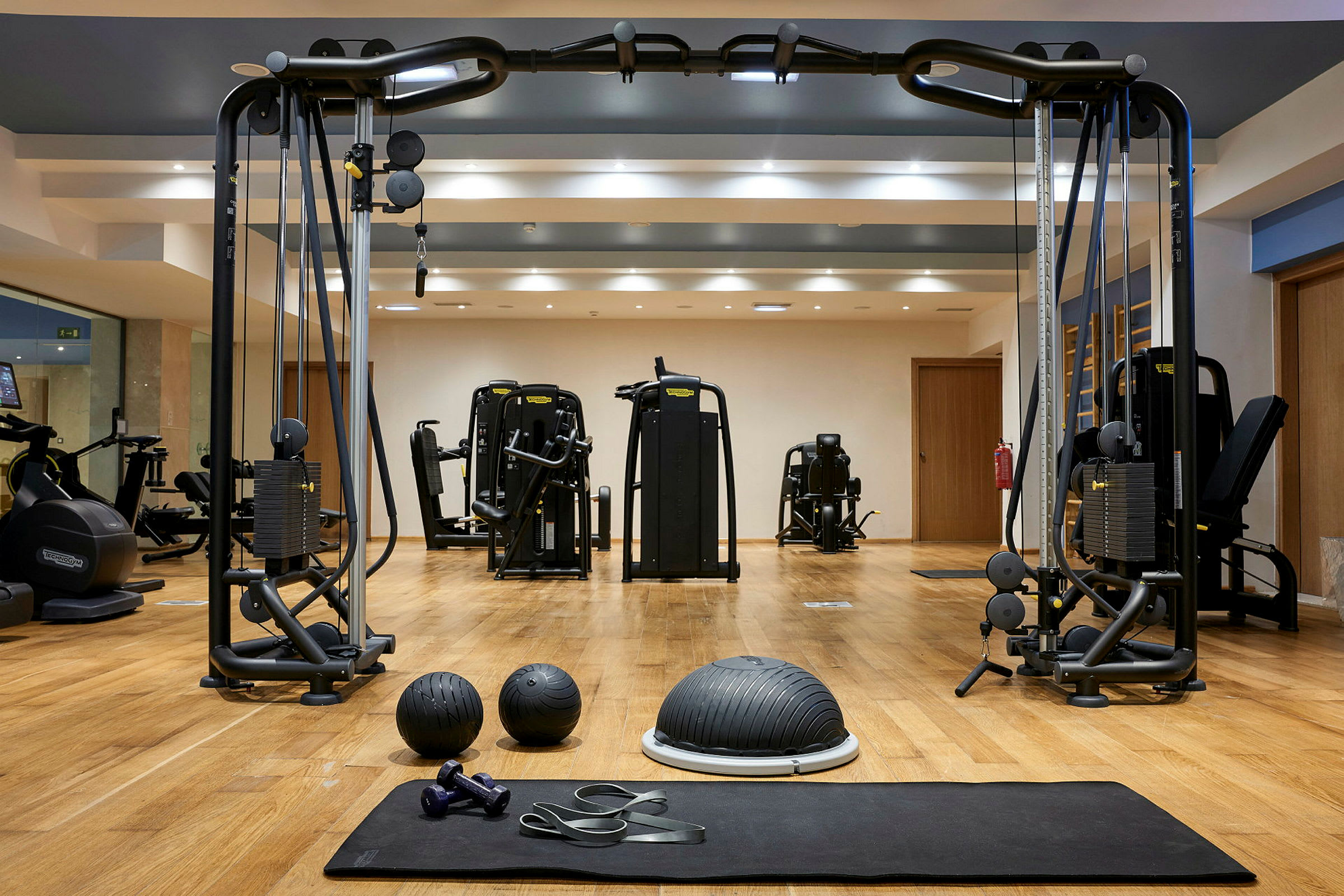 Et fitnesscenter med træningsmaskiner, træningsbolde, håndvægte og modstandsbånd. (AI-genereret tekst)
