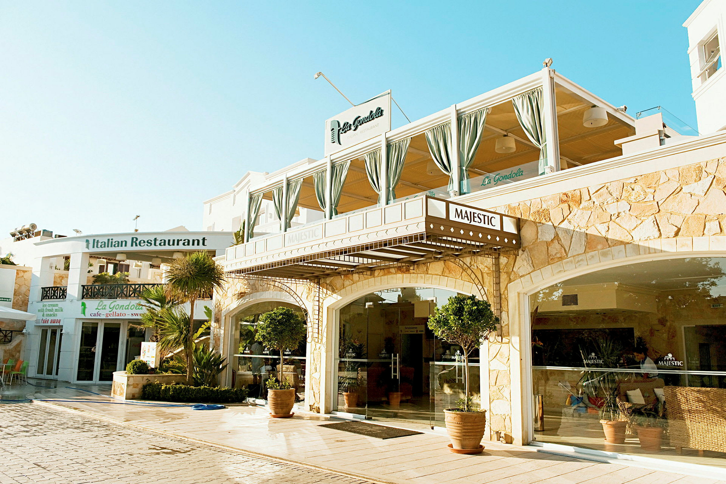 Billede af en bygning med restauranten Majestic ved siden af den italienske restaurant La Gondola. (AI-genereret tekst)