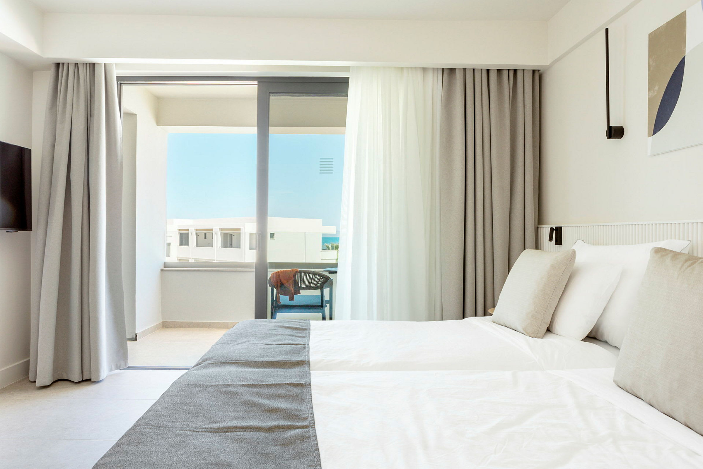 Lyst hotelværelse med dobbeltseng og altan. (AI-genereret tekst)