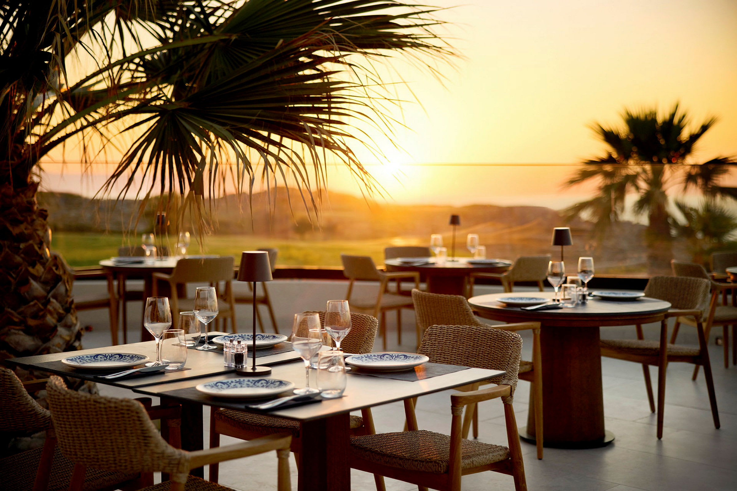 Terrasse med udendørsservering ved solnedgang. (AI-genereret tekst)