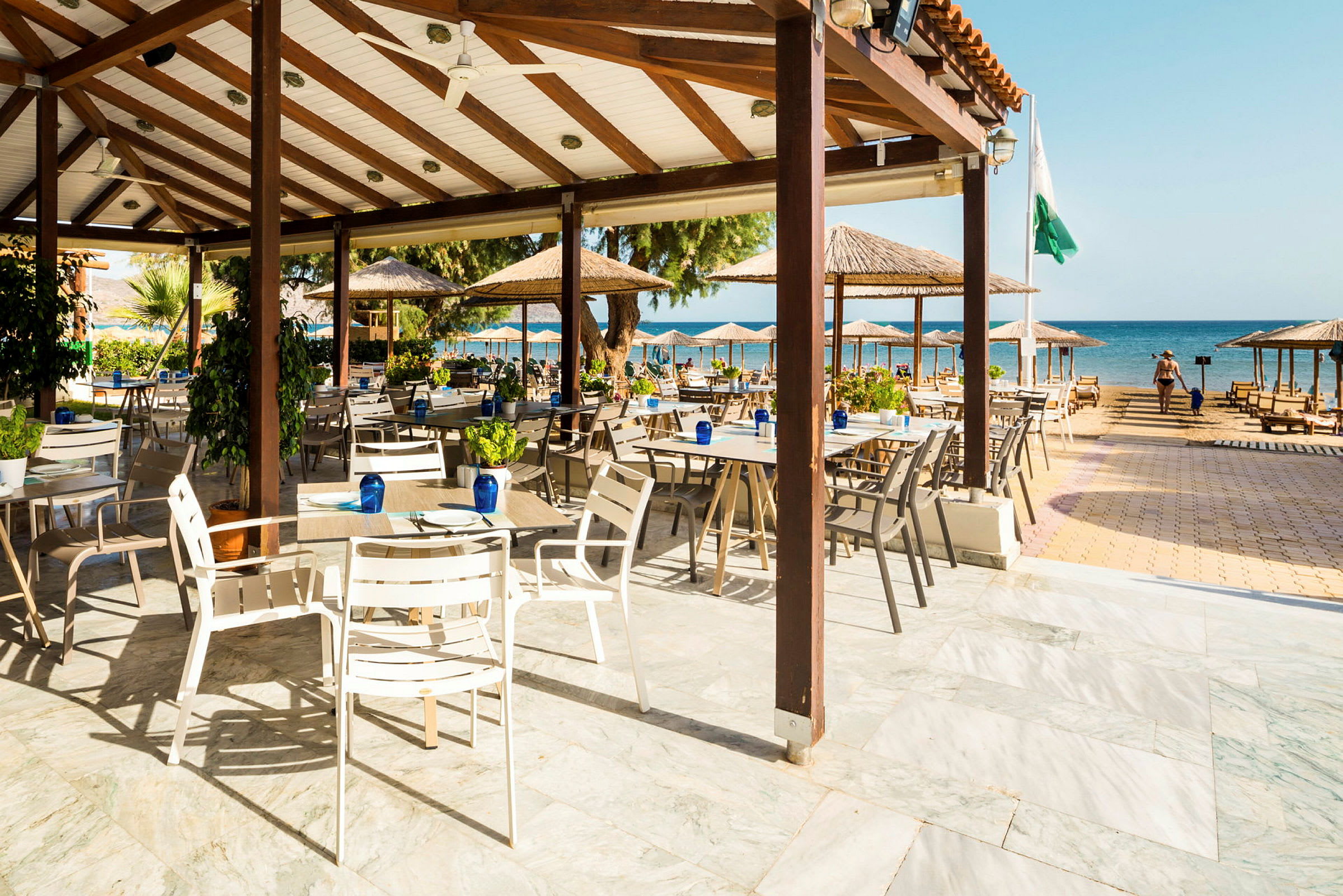 Åben restaurant med udsigt til stranden og havet. (AI-genereret tekst)