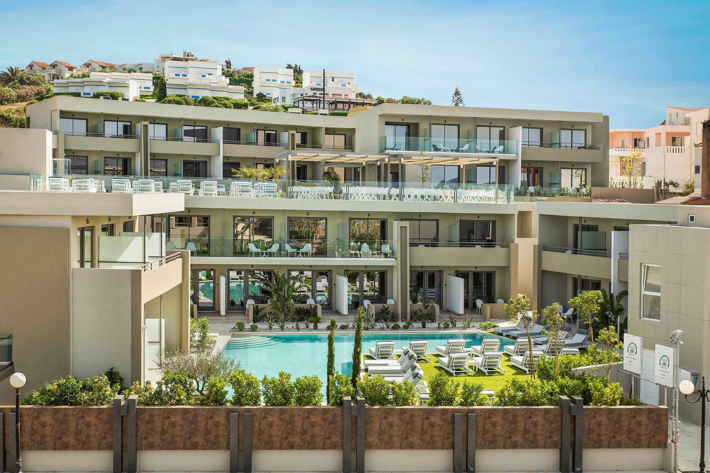 Moderne hotel med poolområde og liggestole. (AI-genereret tekst)