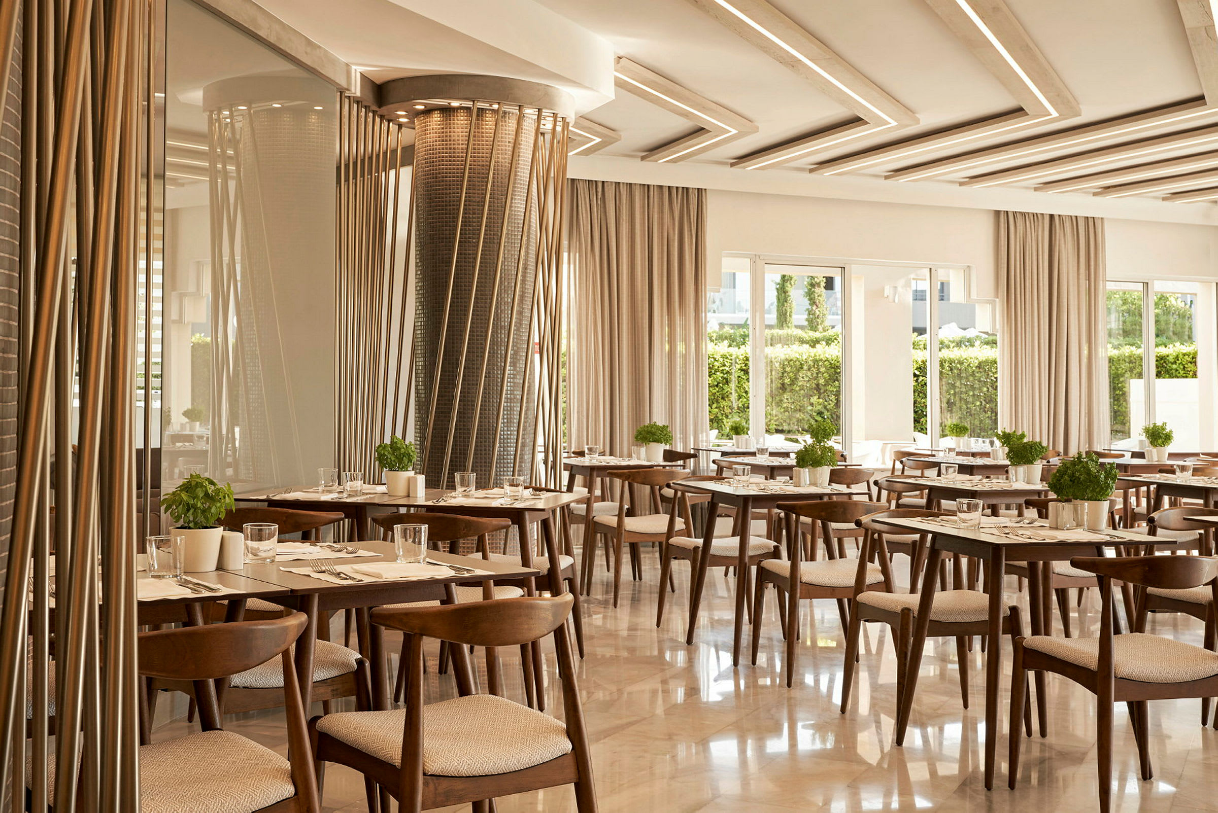 Restaurant med træborde og stole, dekoreret med grønne planter. (AI-genereret tekst)