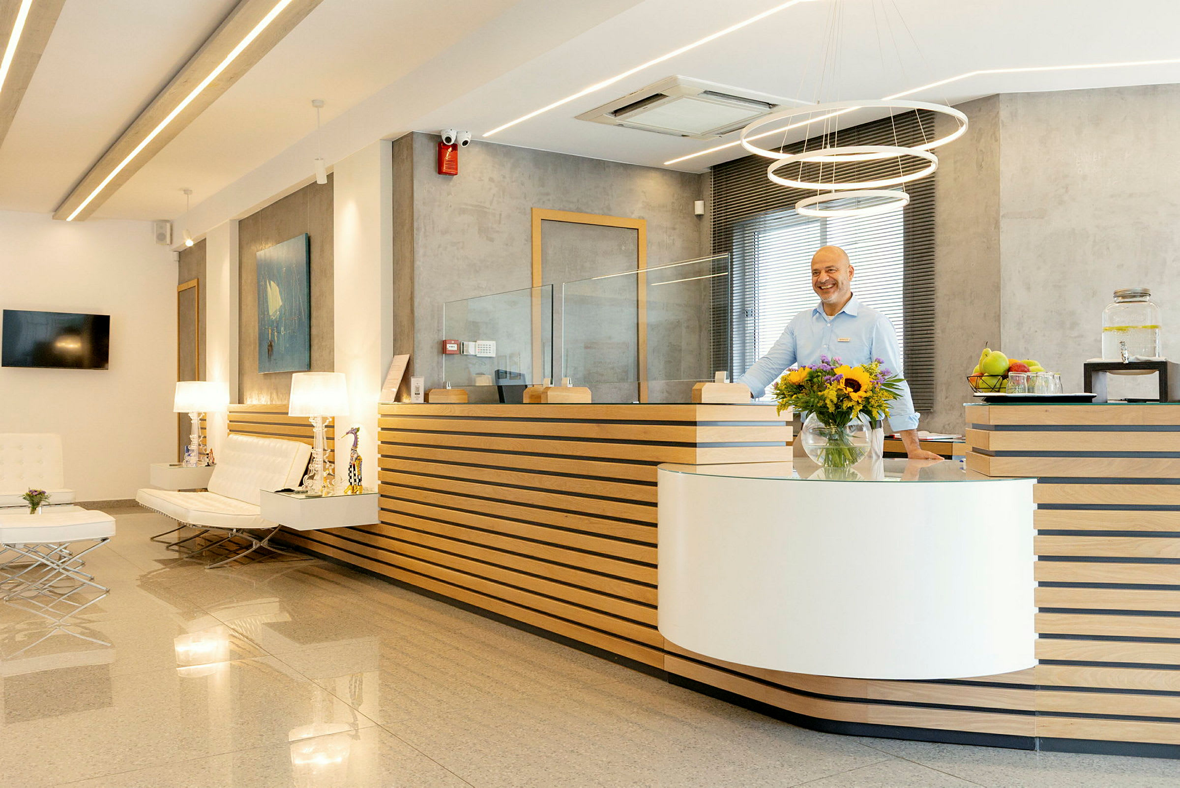 Hotelreception med moderne indretning, blomster og personale ved skranken. (AI-genereret tekst)