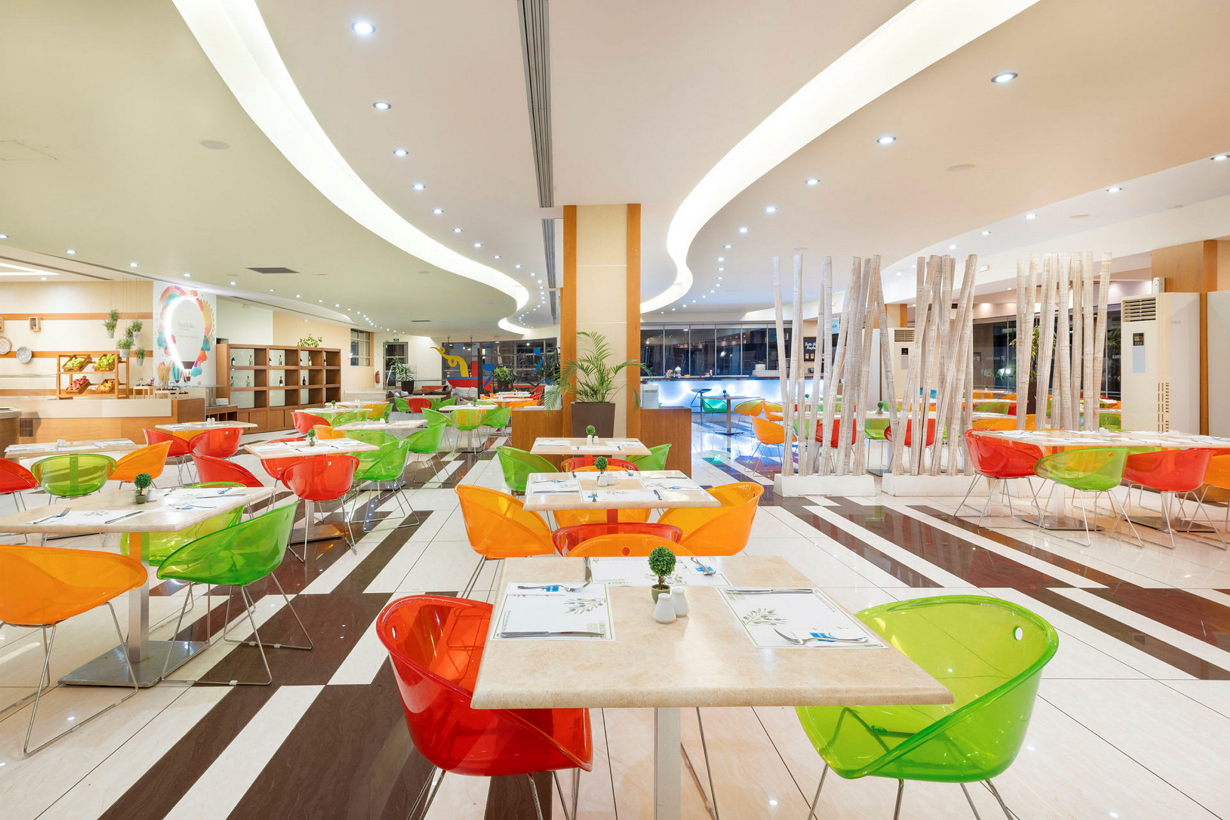 Farverige spiseborde og stole i en moderne restaurantmiljø. (AI-genereret tekst)