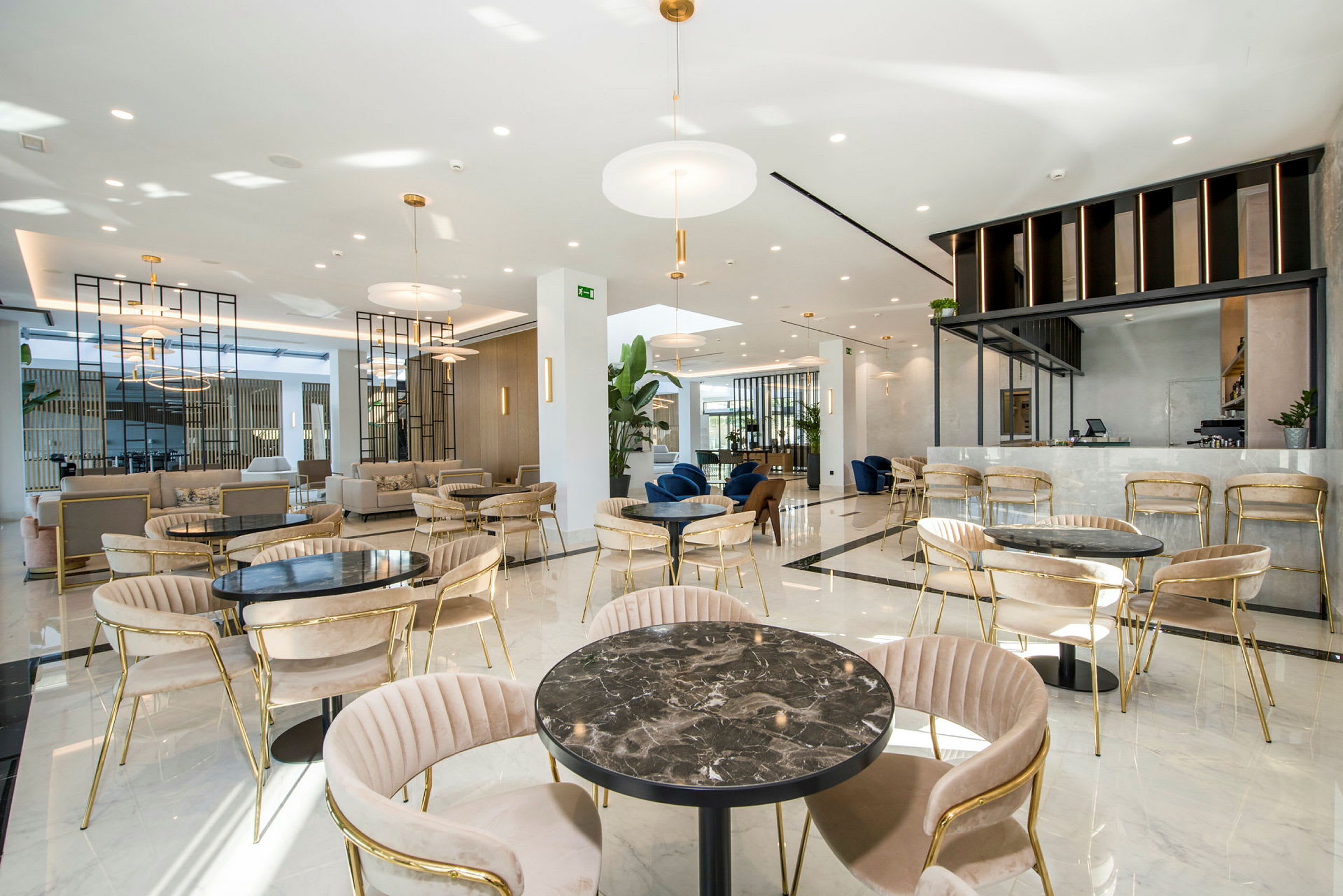 En rummelig lounge med siddegrupper og en moderne indrettet café. (AI-genereret tekst)