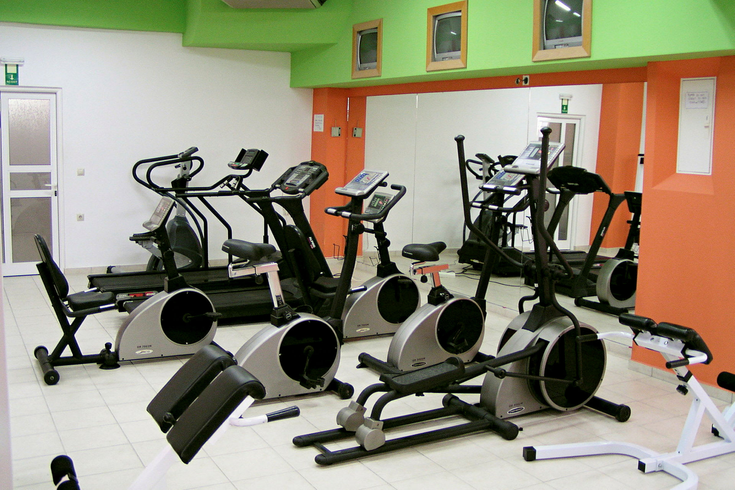 Et fitnesscenter med træningsmaskiner inklusive motionscykler, løbebånd og andre konditionsmaskiner. (AI-genereret tekst)