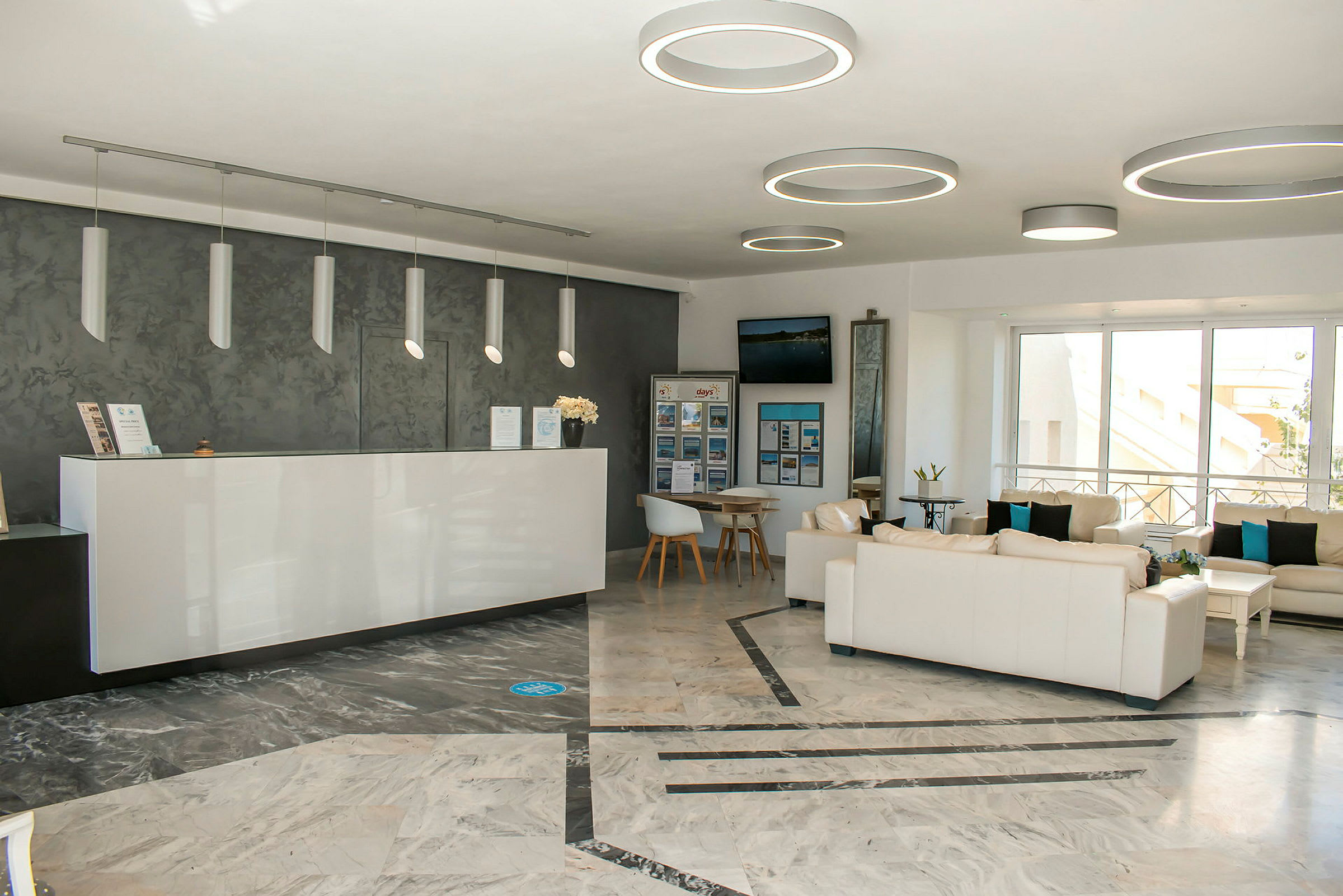 Et lyst og moderne indrettet receptionsområde med sofagrupper og en reception. (AI-genereret tekst)