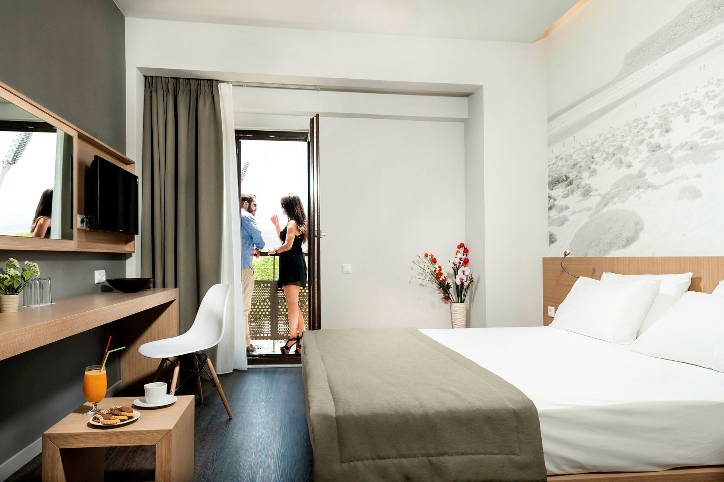 Moderne hotelværelse med dobbeltseng, skrivebord og udsigt til en altan. (AI-genereret tekst)