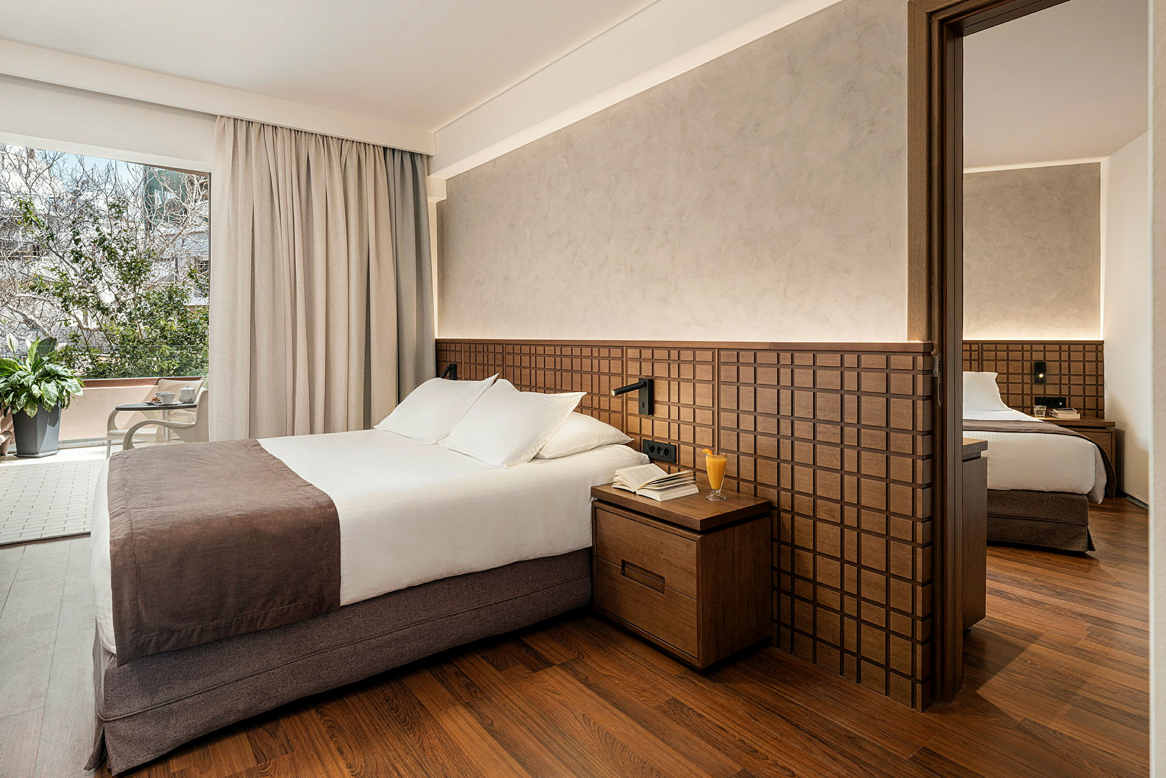 Hotelværelse med dobbeltseng, natbord og garderobe. (AI-genereret tekst)