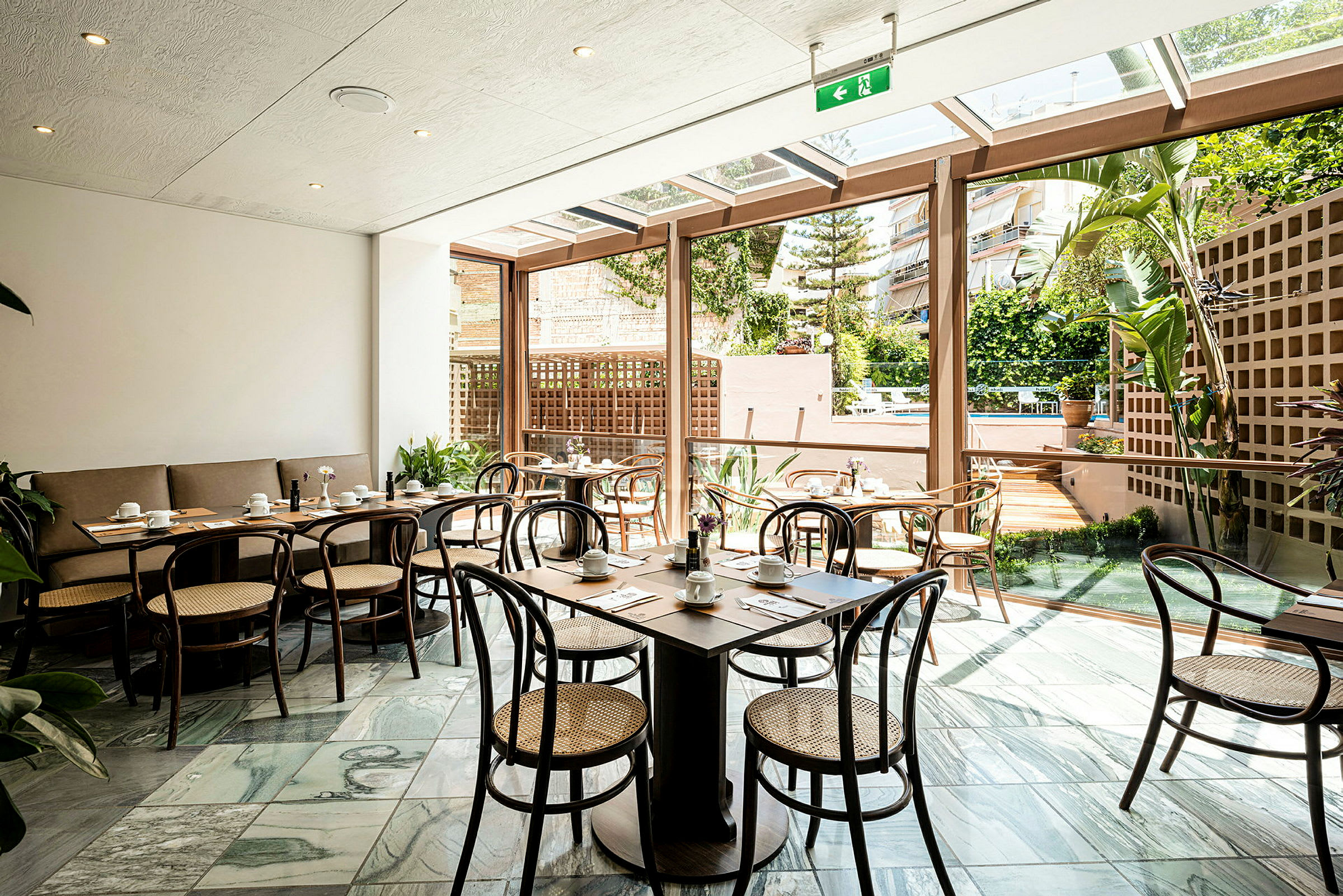 Billede af restaurant med vinduer mod udendørsområde. (AI-genereret tekst)