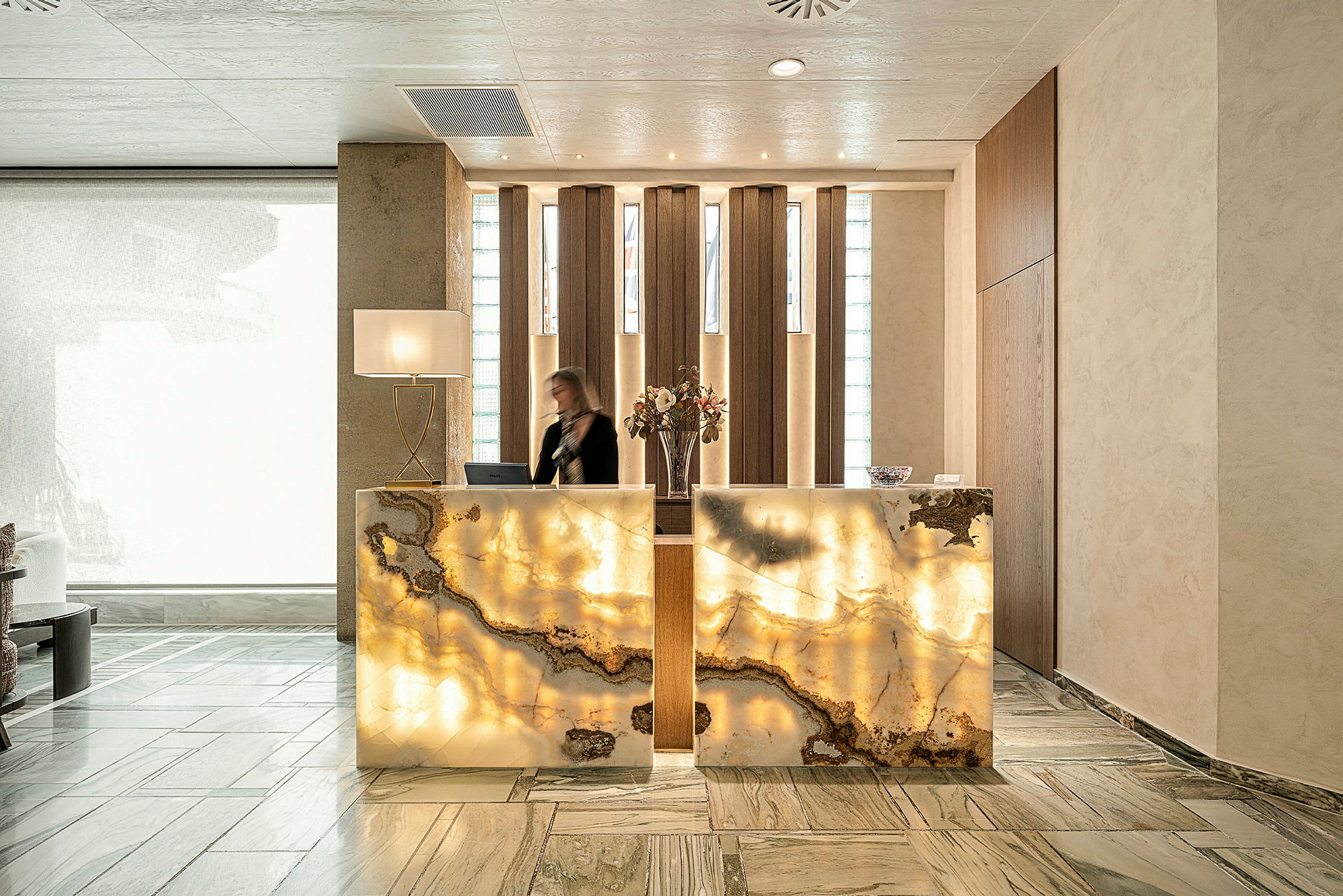 Hotelreception med elegant marmoreret skranke og moderne interiør. (AI-genereret tekst)