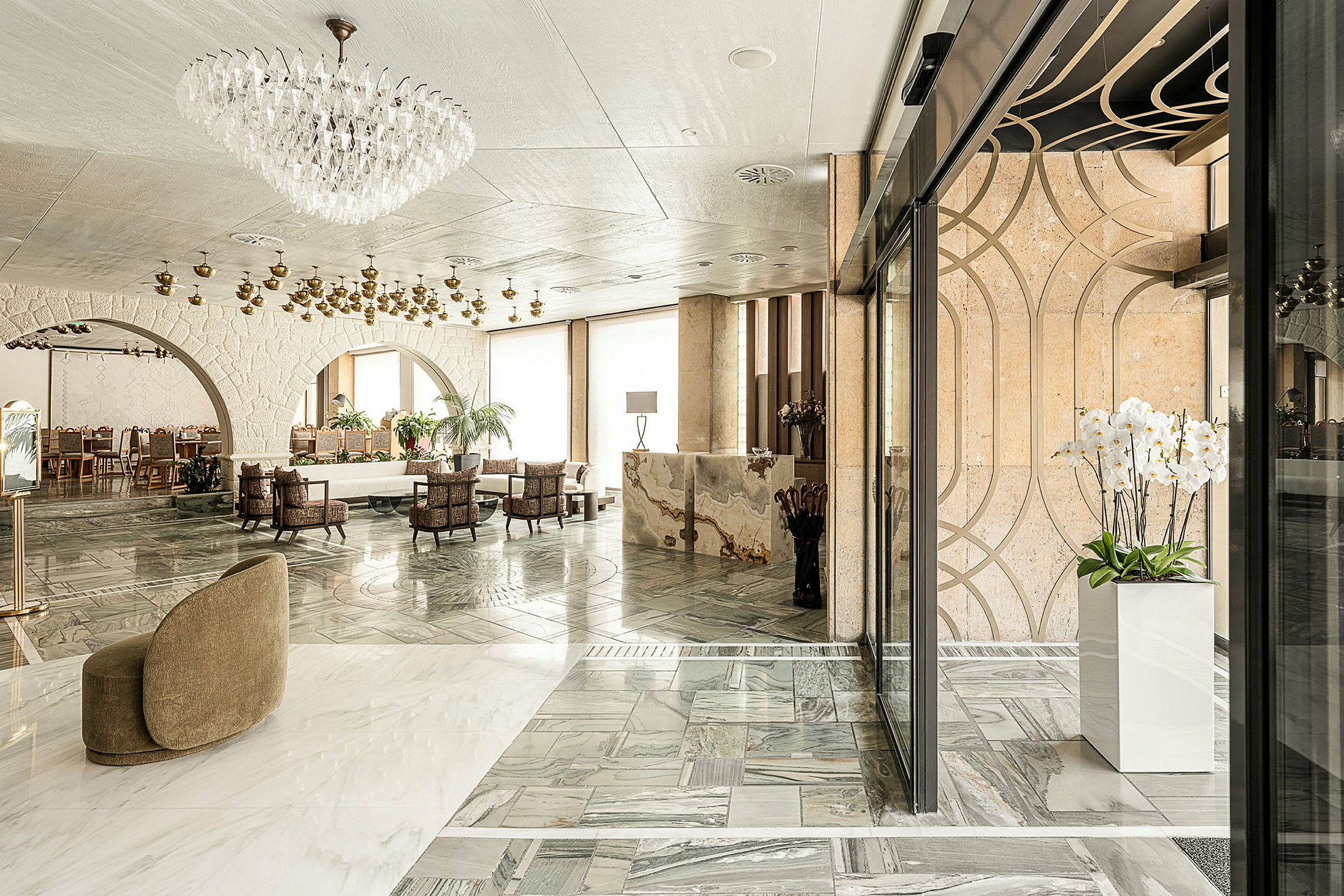 Elegant hotellobby med marmorgulv, lysekrone og moderne møbler. (AI-genereret tekst)