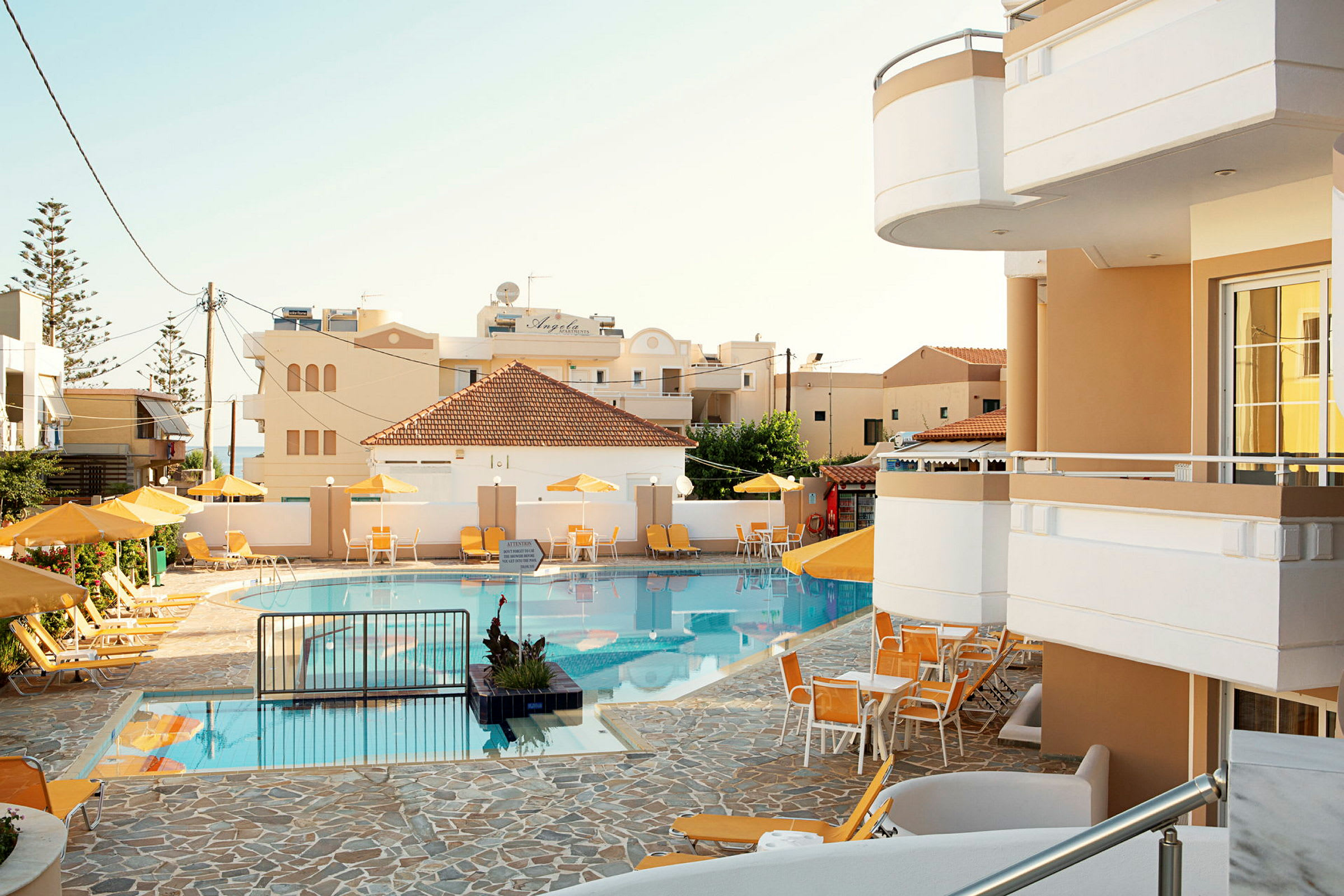 En pool med liggestole og parasoller ved et hotel. (AI-genereret tekst)