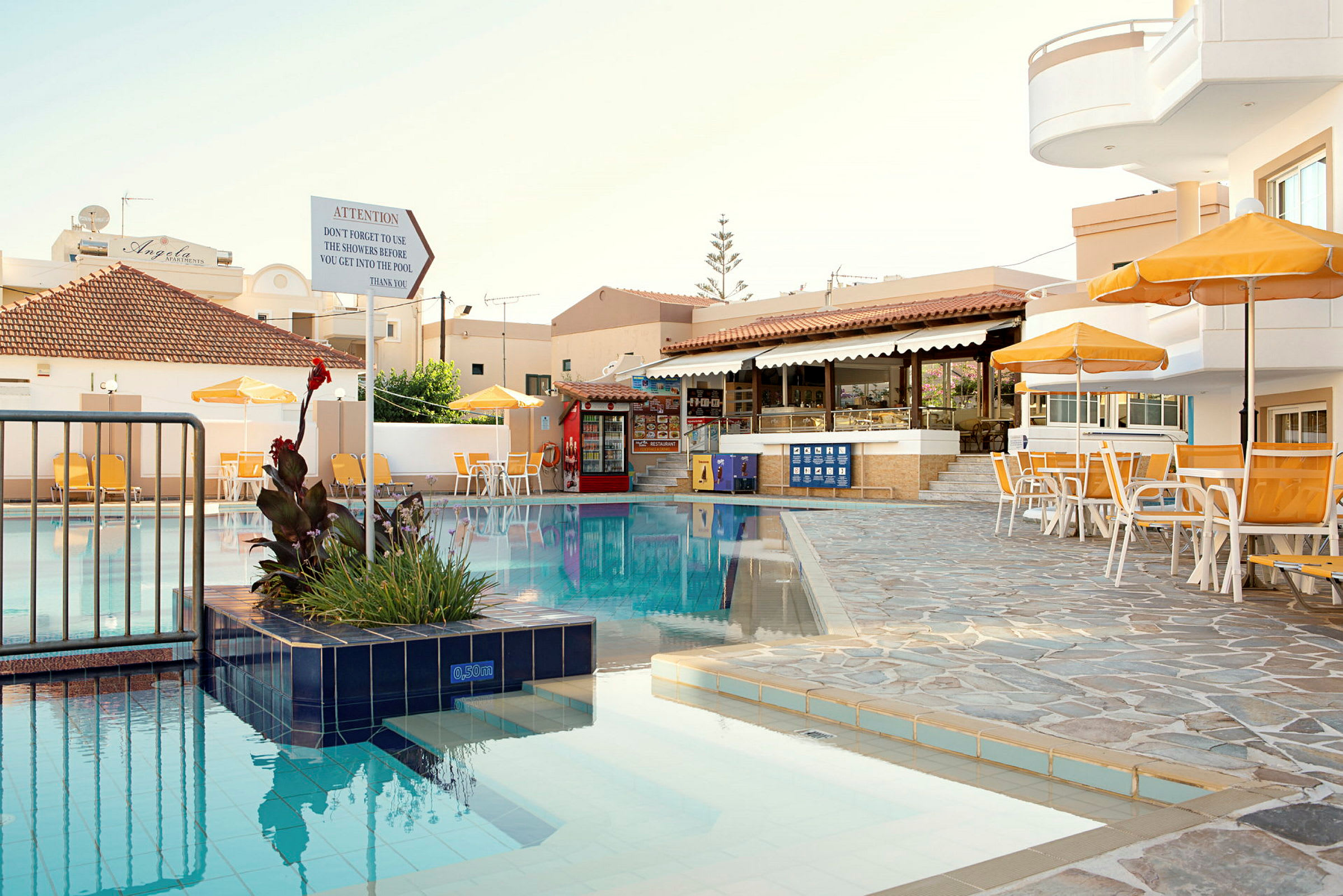 Udendørs swimmingpool ved hotel med liggestole og parasoller. (AI-genereret tekst)
