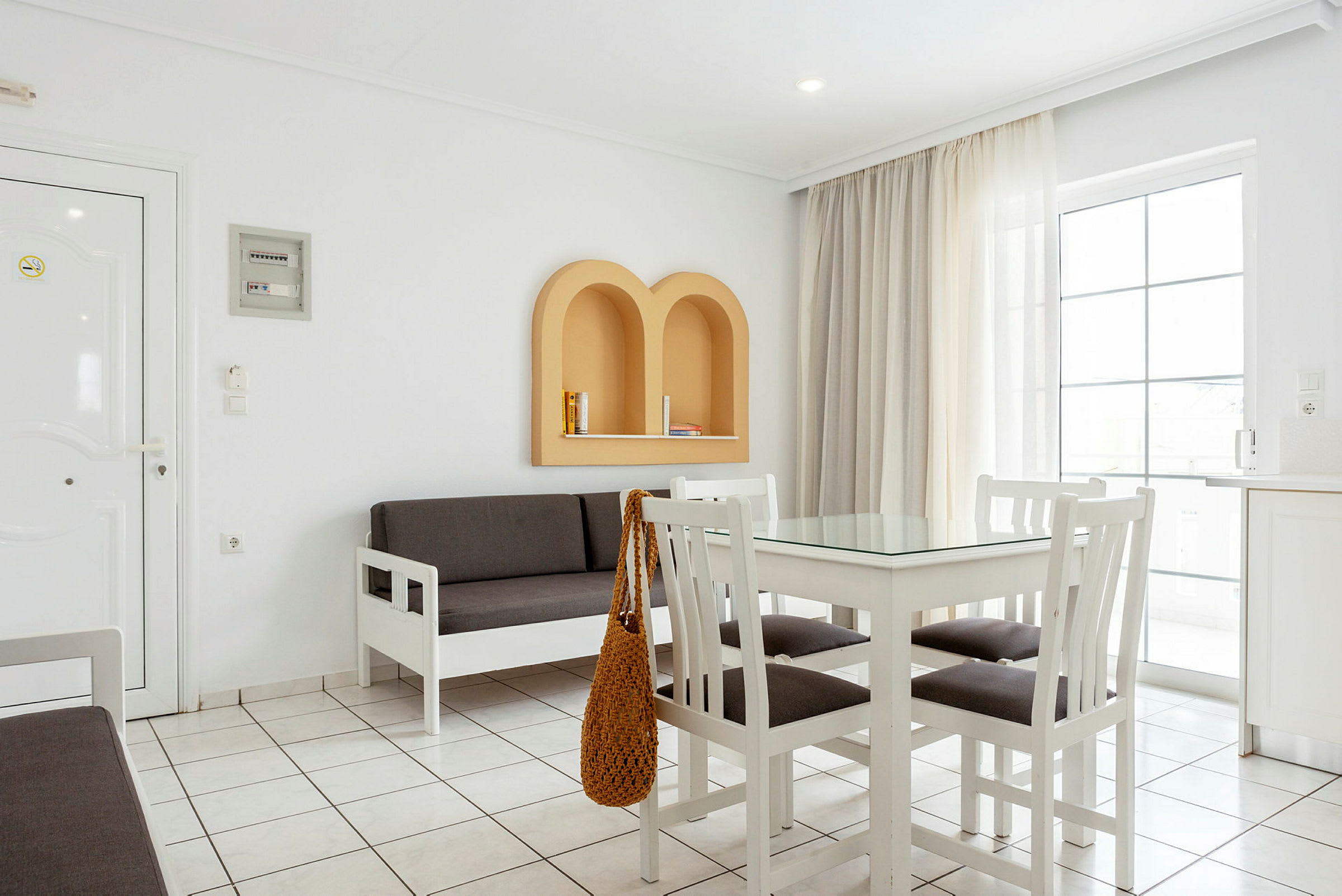 Et lyst interiør med hvide møbler, en grå sofa og beige detaljer på væggen. (AI-genereret tekst)