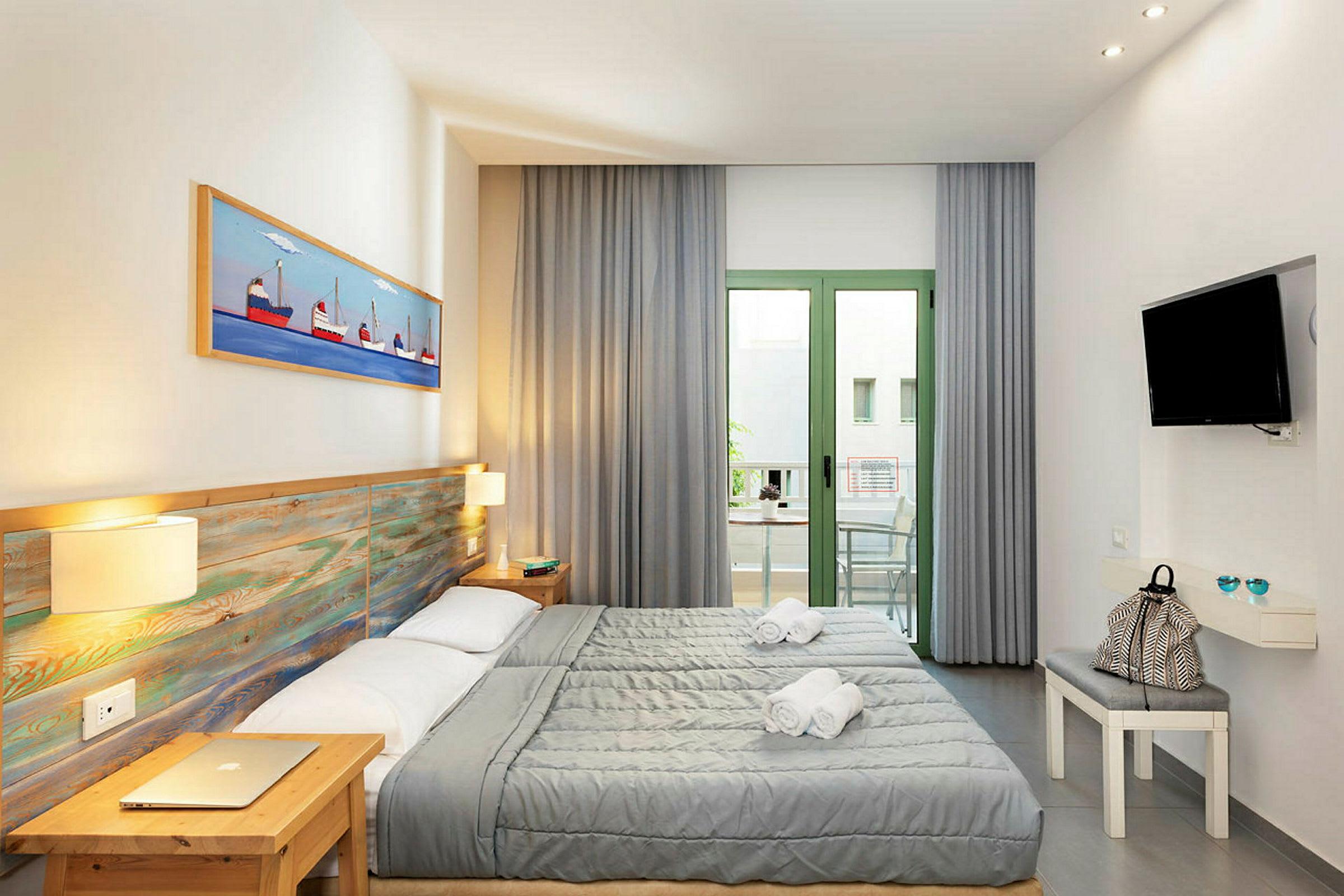 Et hotelværelse med to enkeltsenge, en møbleret balkon og et vægmonteret TV. (AI-genereret tekst)