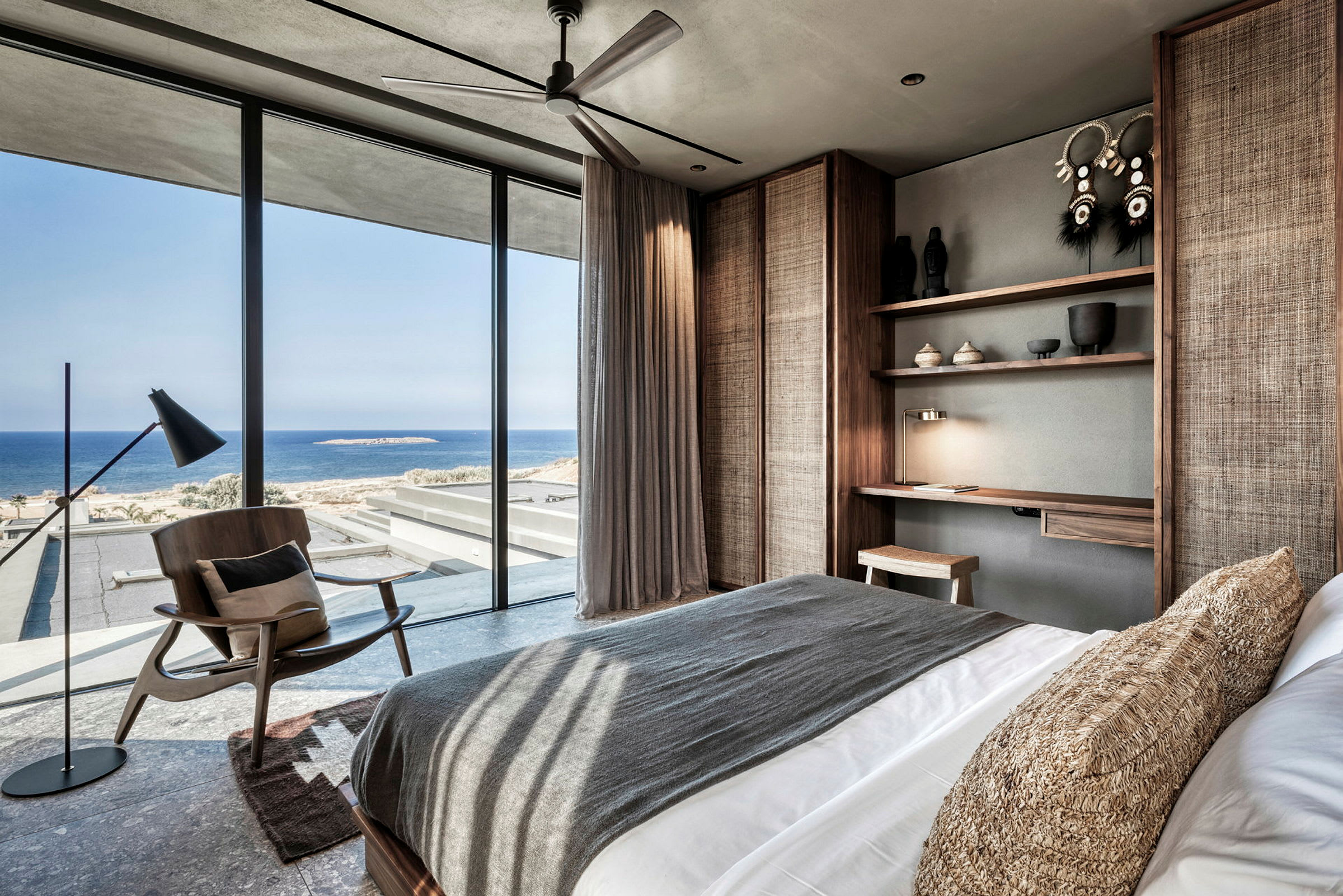 Moderne hotelværelse med havudsigt gennem store vinduer. (AI-genereret tekst)