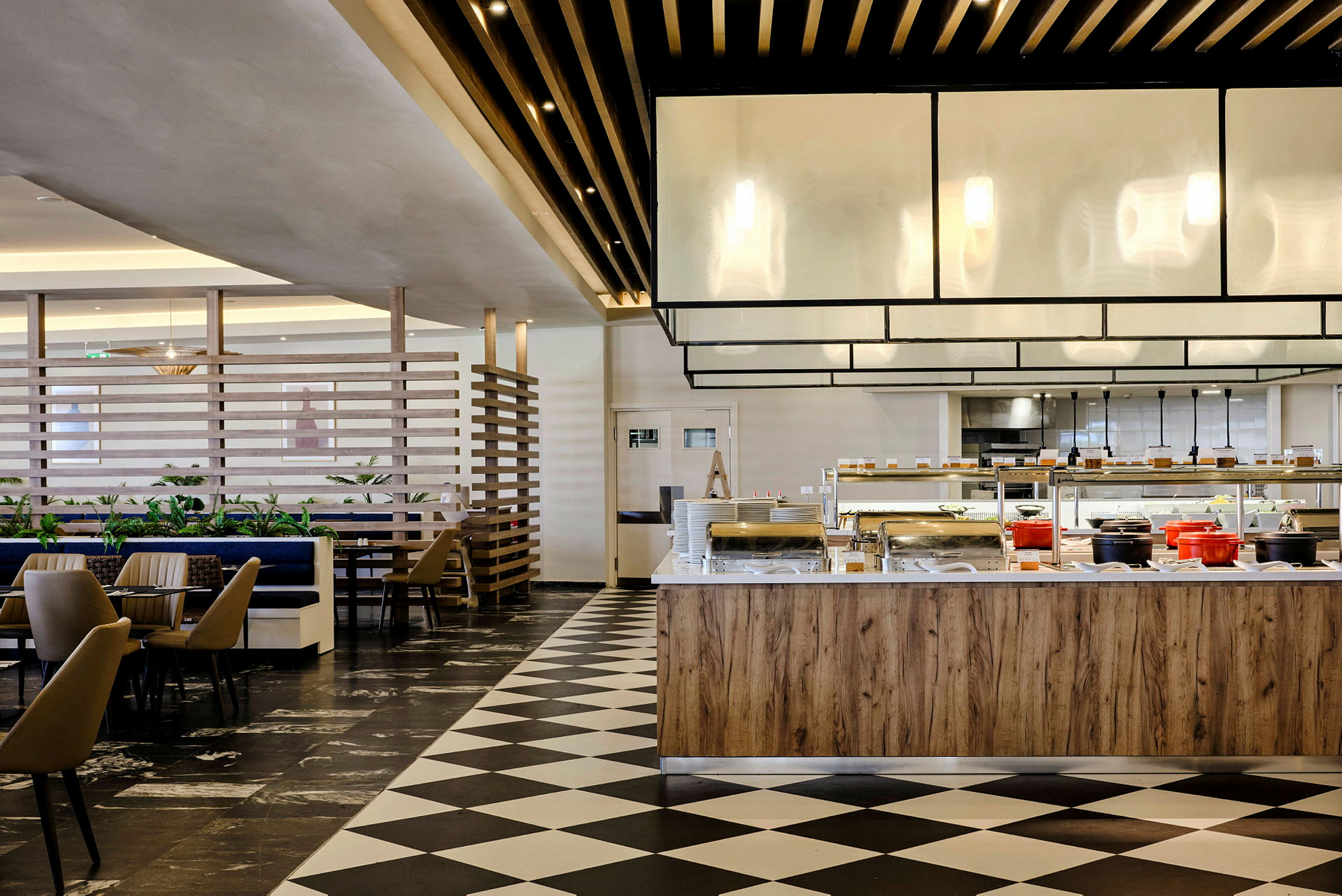 Interiør af en restaurant med buffetområde og siddepladser. (AI-genereret tekst)
