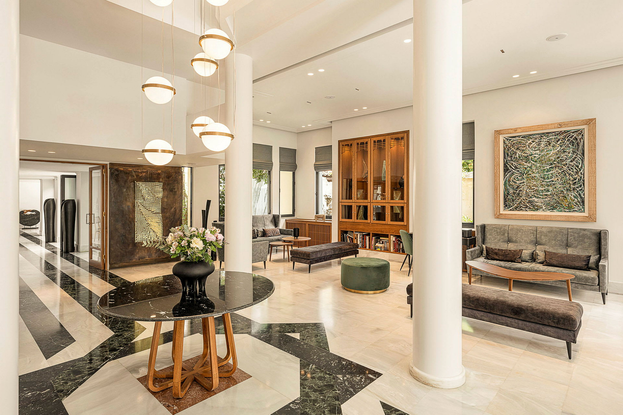 Moderne designet hotellobby med marmorgulv, lyse møbler og hængende lamper. (AI-genereret tekst)