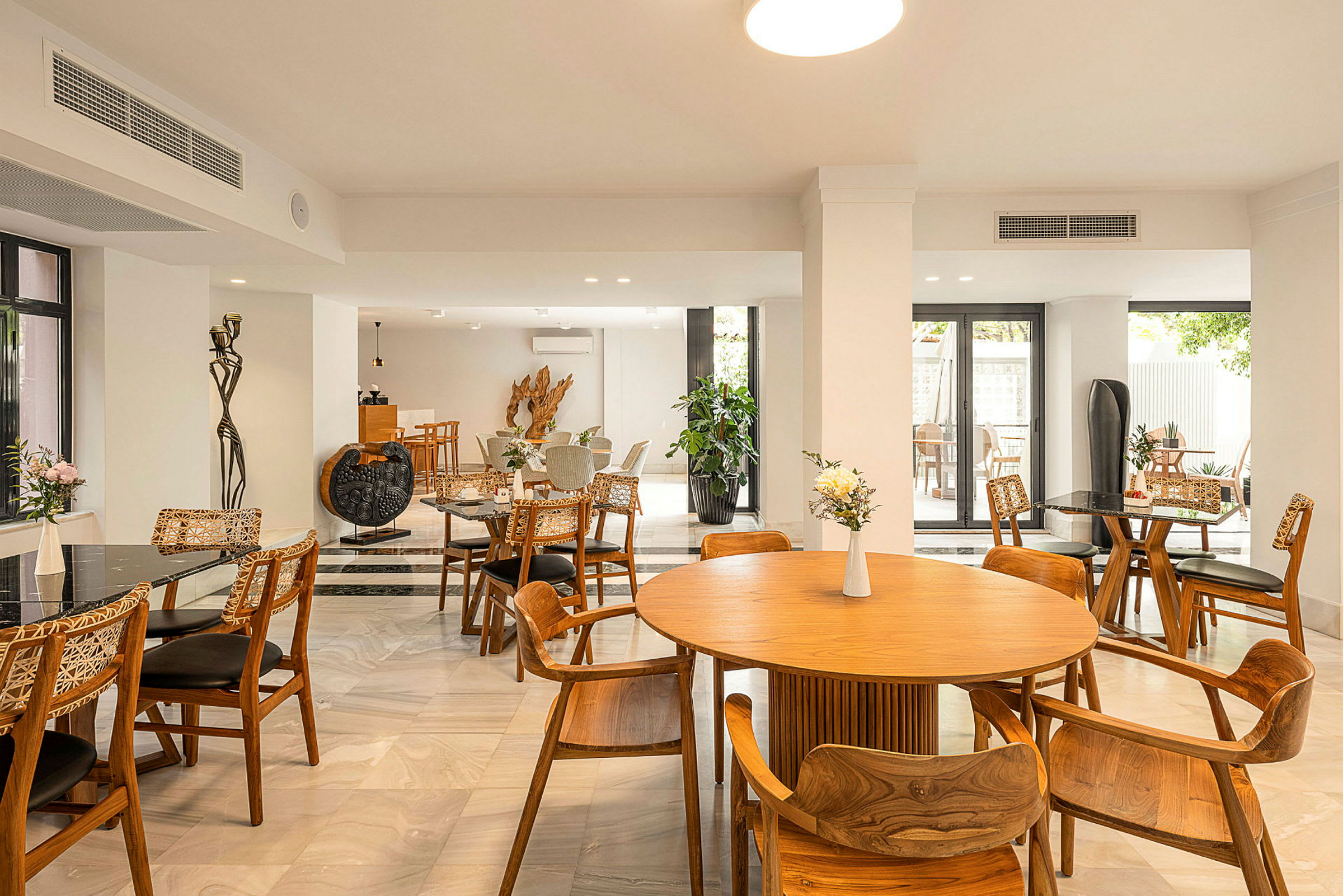 En indendørs restaurant med borde og stole af træ og moderne indretning. (AI-genereret tekst)