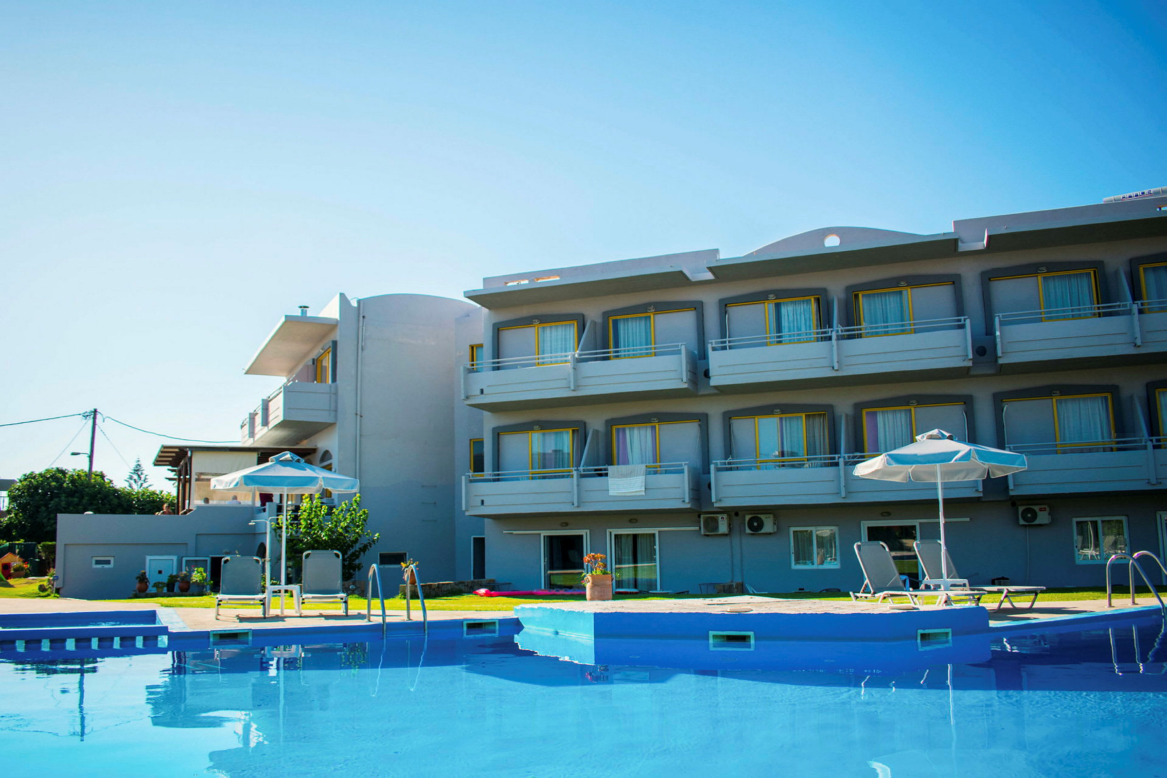 Et hotel med altaner og en pool i forgrunden. (AI-genereret tekst)