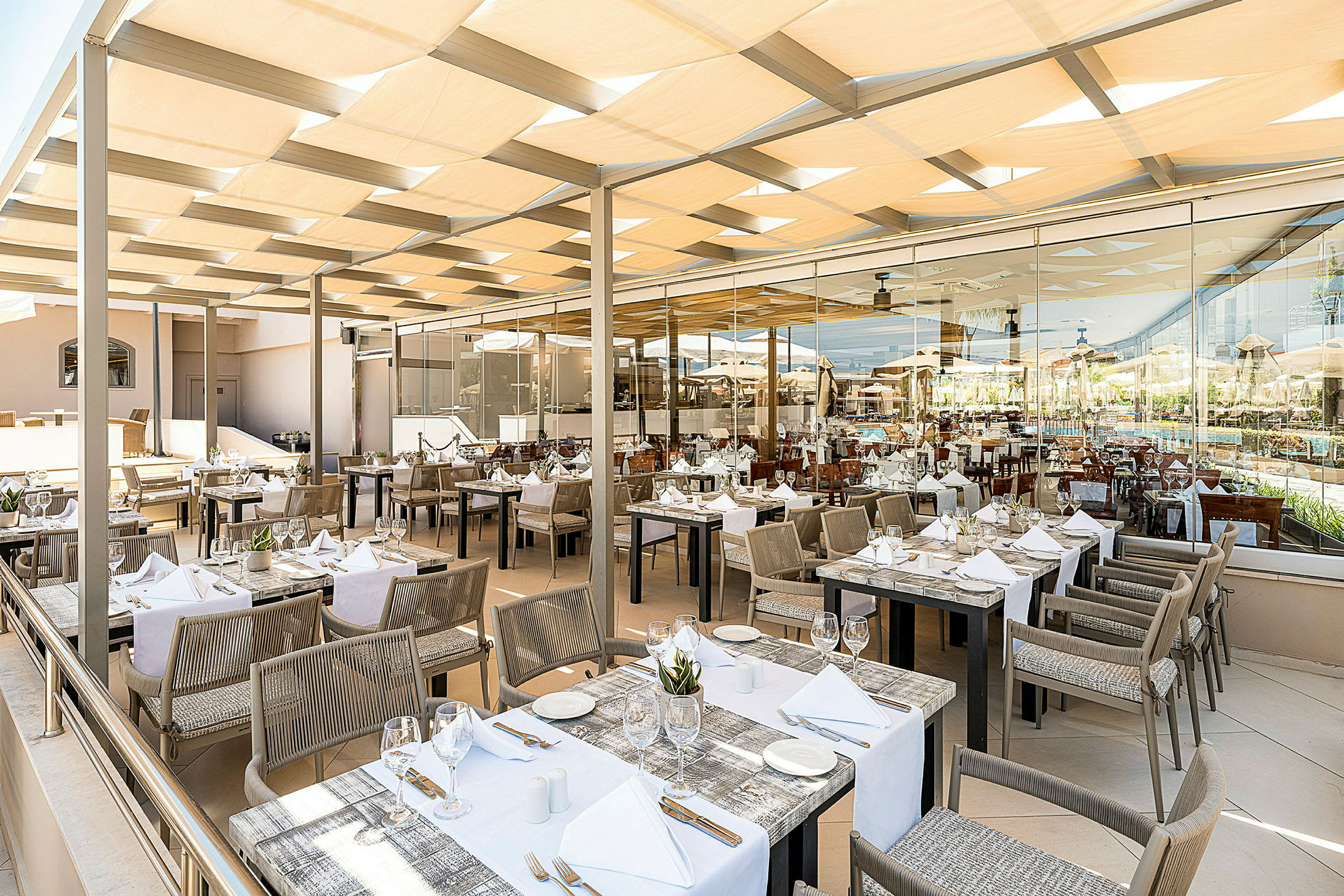Restaurant med dækkede borde udendørs under tag. (AI-genereret tekst)