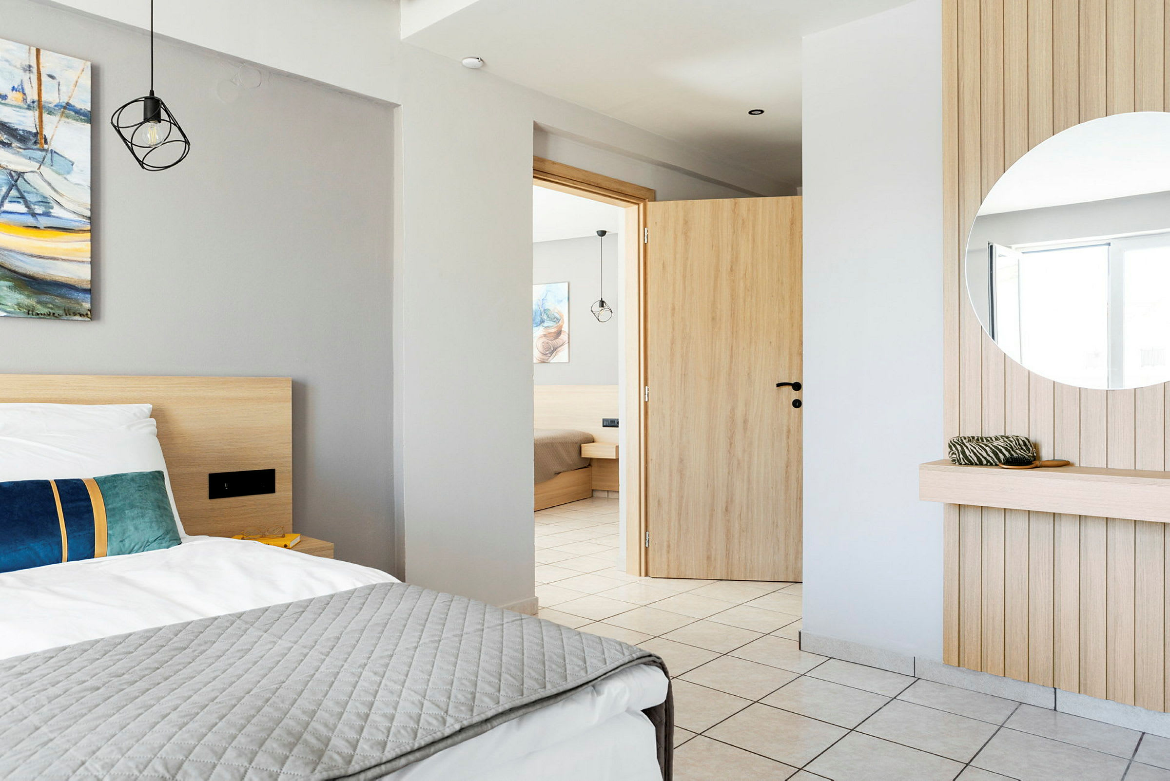 Interiøret i et hotelværelse med en seng, et spejl og en åben dør. (AI-genereret tekst)