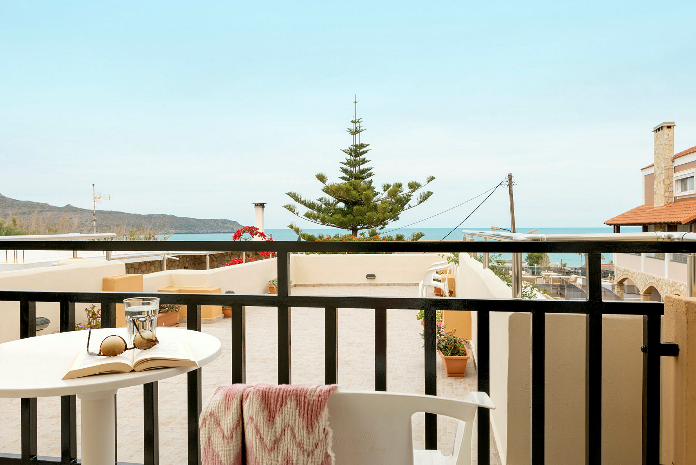 En balkon med udsigt over havet og nærliggende bygninger. (AI-genereret tekst)