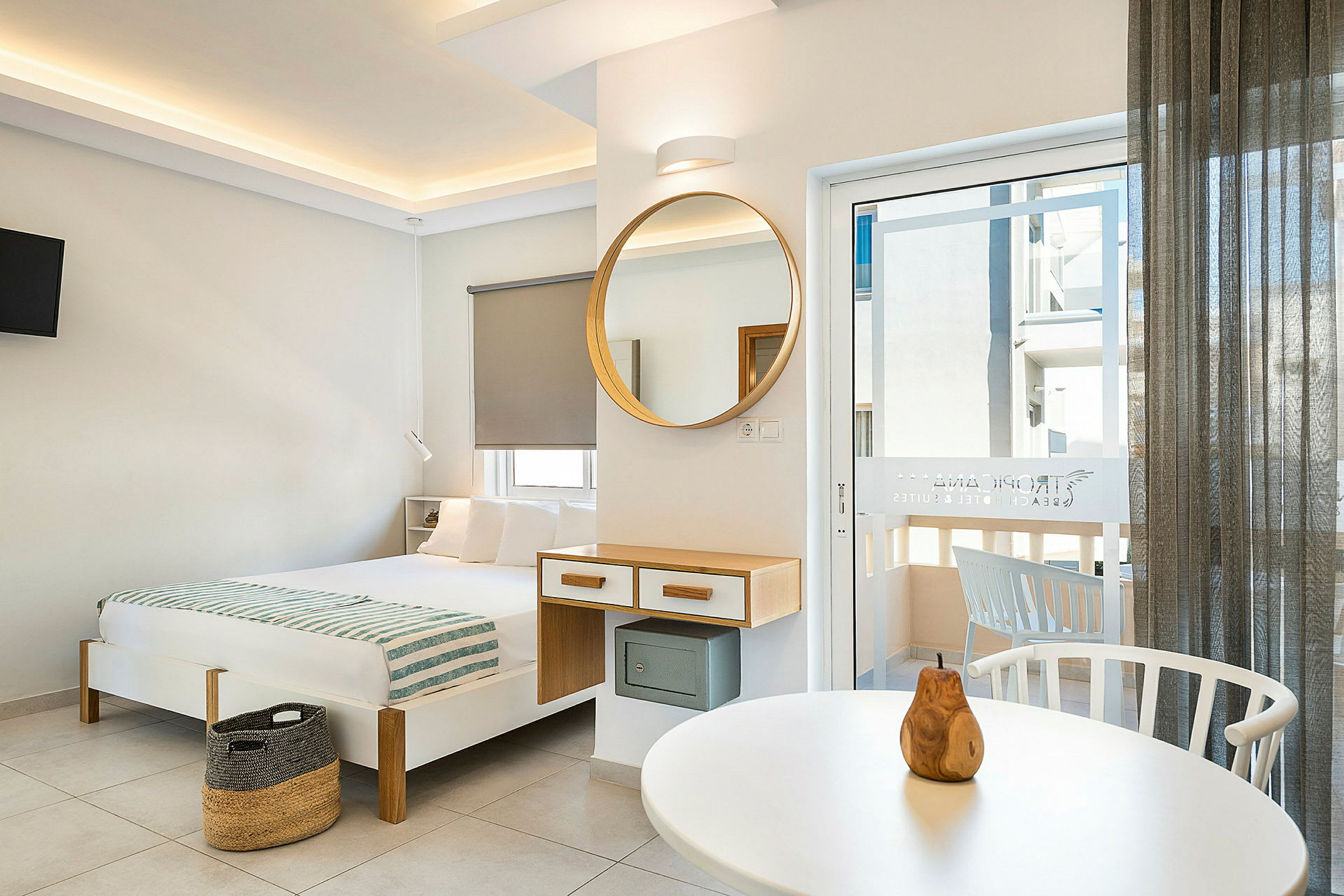 Moderne indrettet hotelværelse med seng, spejl og altandør. (AI-genereret tekst)