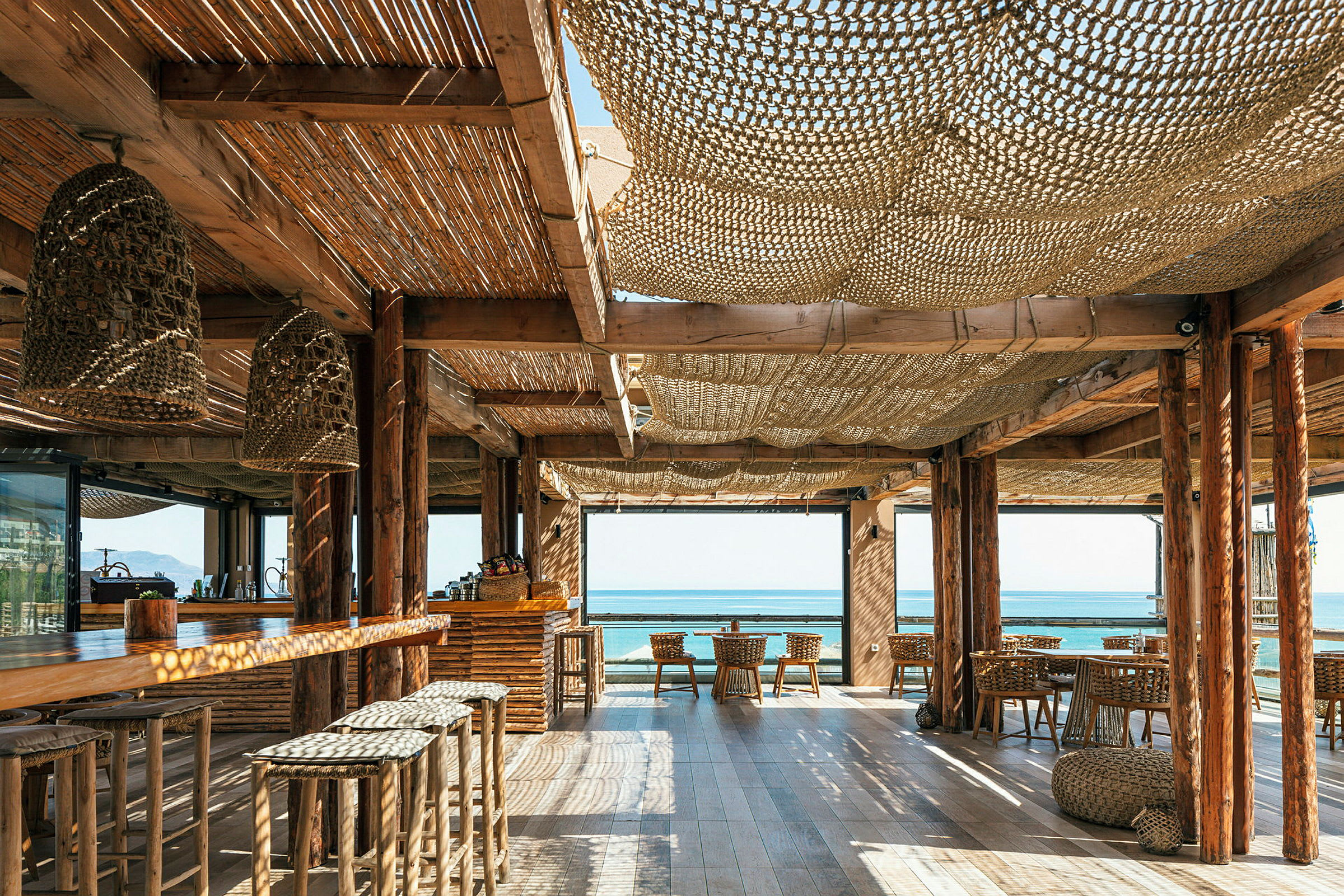 En strandrestaurant med træinteriør og udsigt til havet. (AI-genereret tekst)