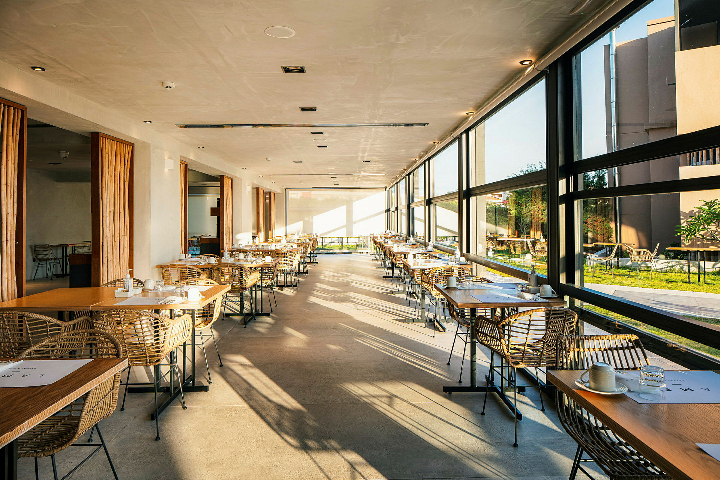Restaurant med store vinduer og dækkede borde. (AI-genereret tekst)