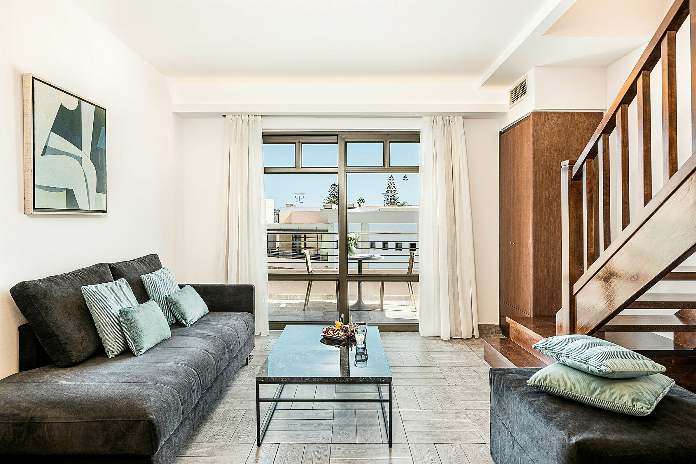 En stue med en sofa, et bord og en trappe, samt en balkon med udsigt. (AI-genereret tekst)