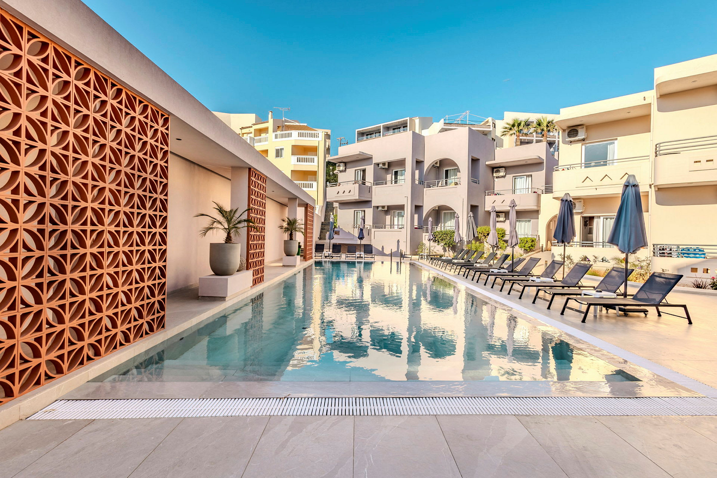 Udendørs pool ved hotel med designede detaljer og liggestole rundt omkring. (AI-genereret tekst)