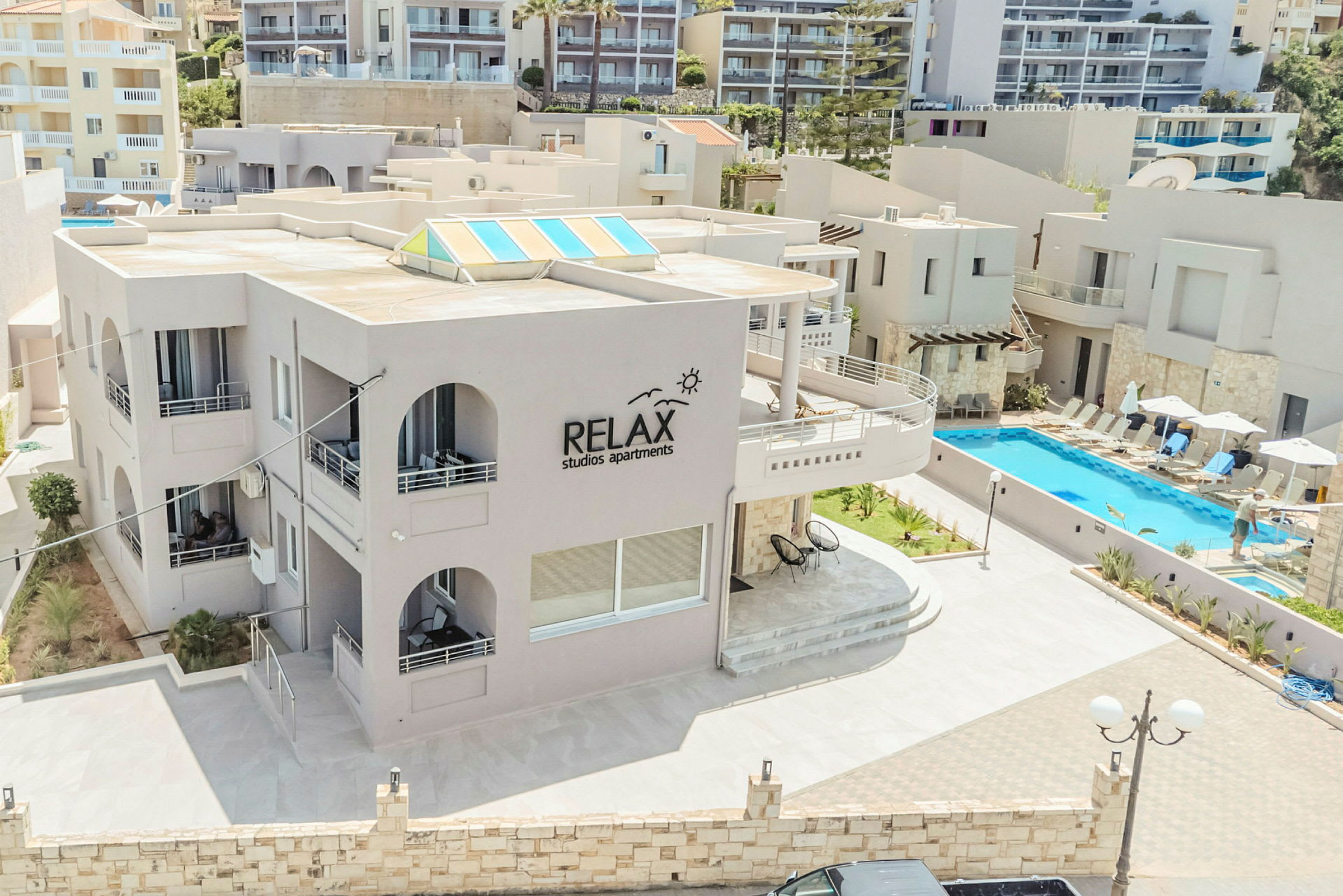 Udendørsområde ved Relax Studios Apartments, med pool og liggestole. (AI-genereret tekst)