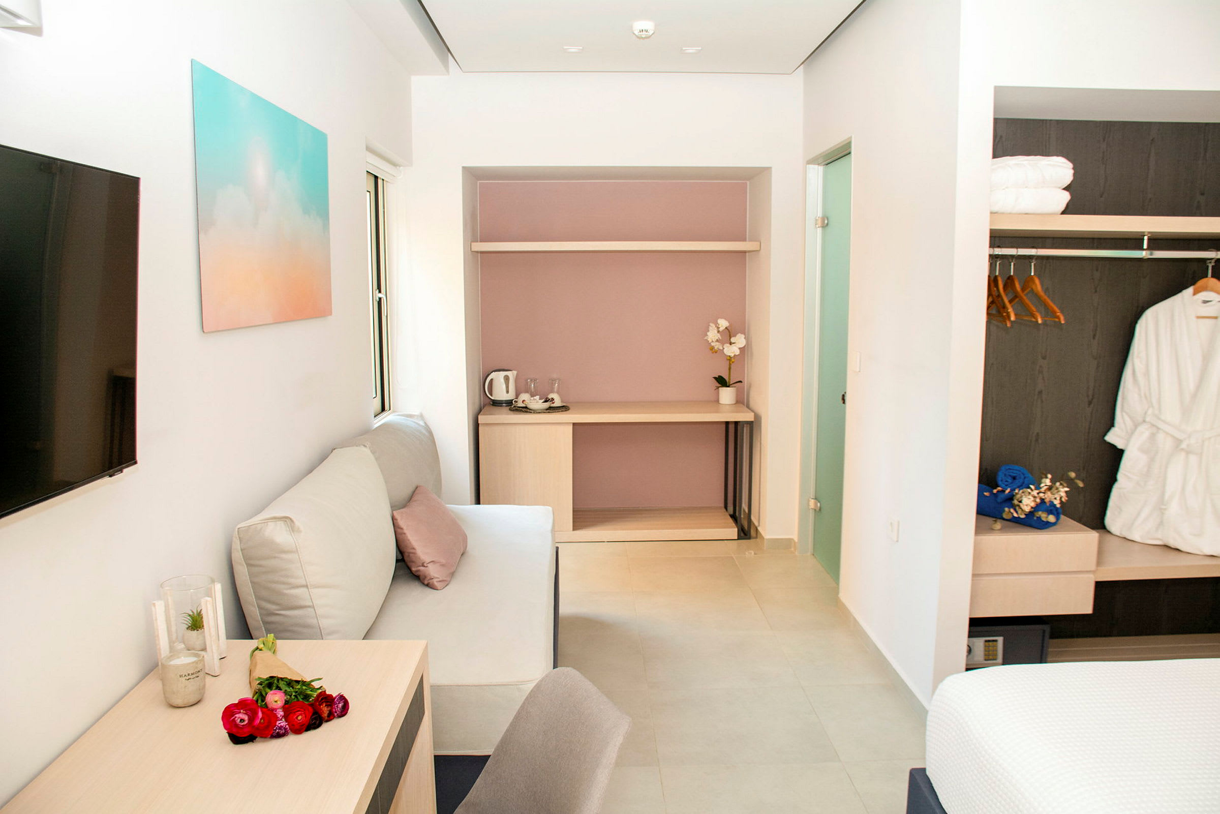 Et moderne hotelværelse med sofa, bord og garderobe. (AI-genereret tekst)