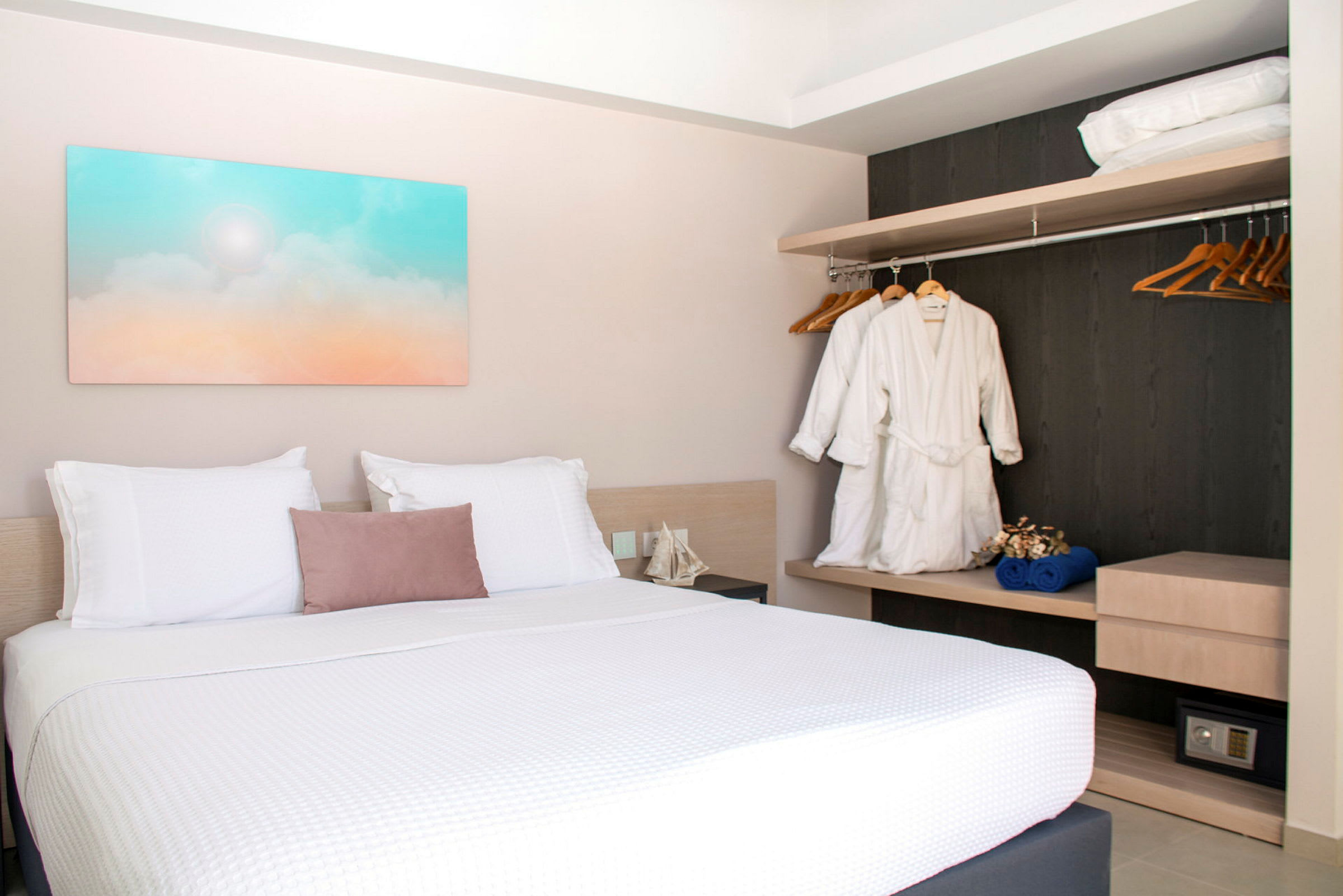 Hotelværelse med dobbeltseng, vægkunst og garderobe. (AI-genereret tekst)