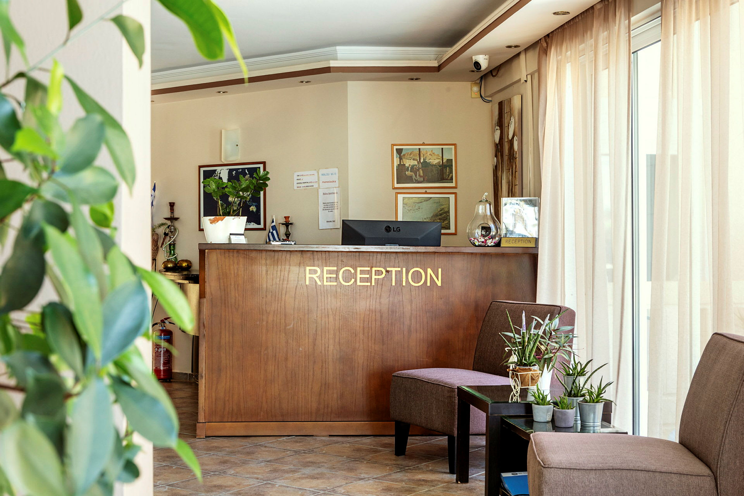 Hotellets reception med skrivebord, planter og siddepladser. (AI-genereret tekst)