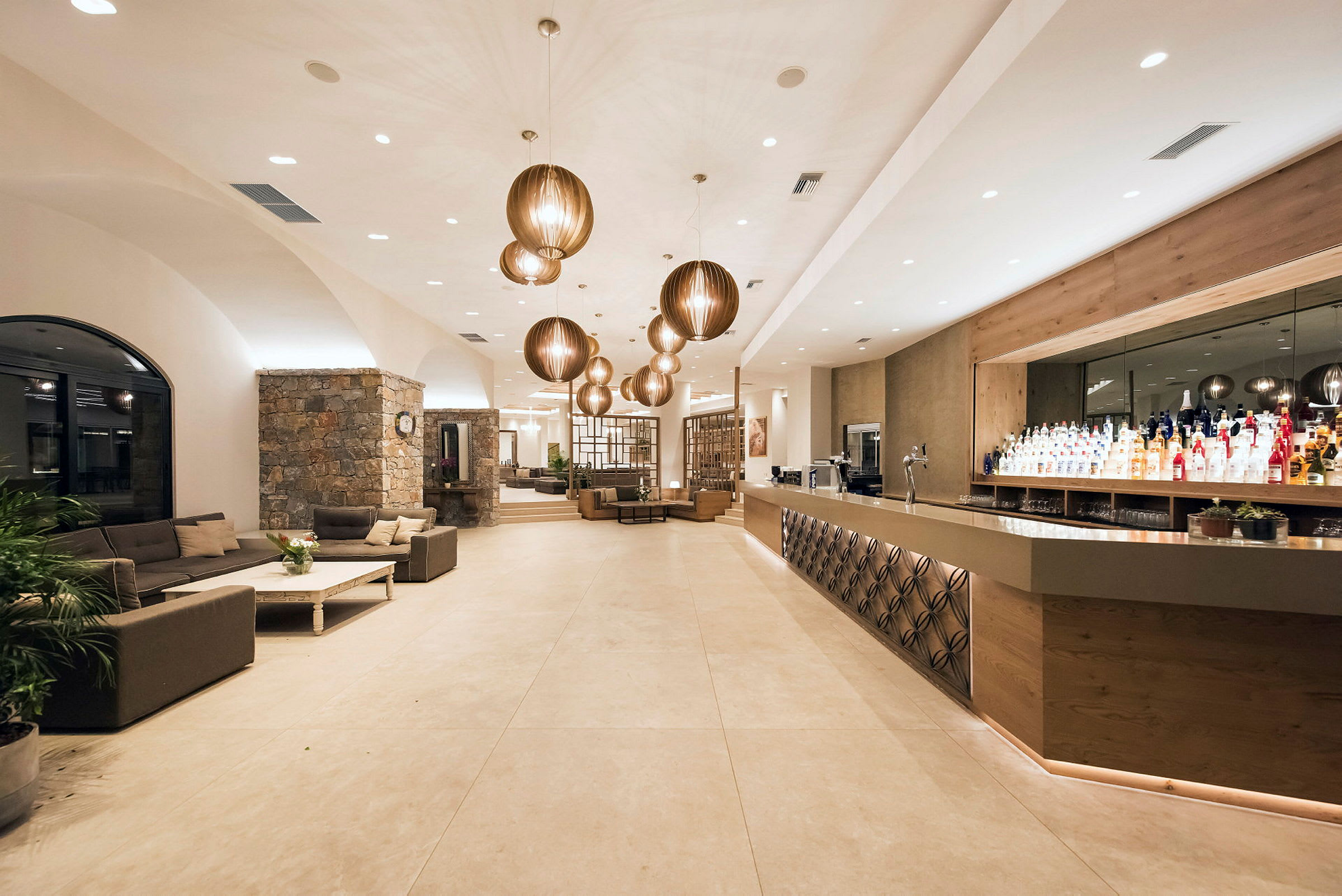 Moderne og velbelyst hotellobby med sofaer og bardisk. (AI-genereret tekst)
