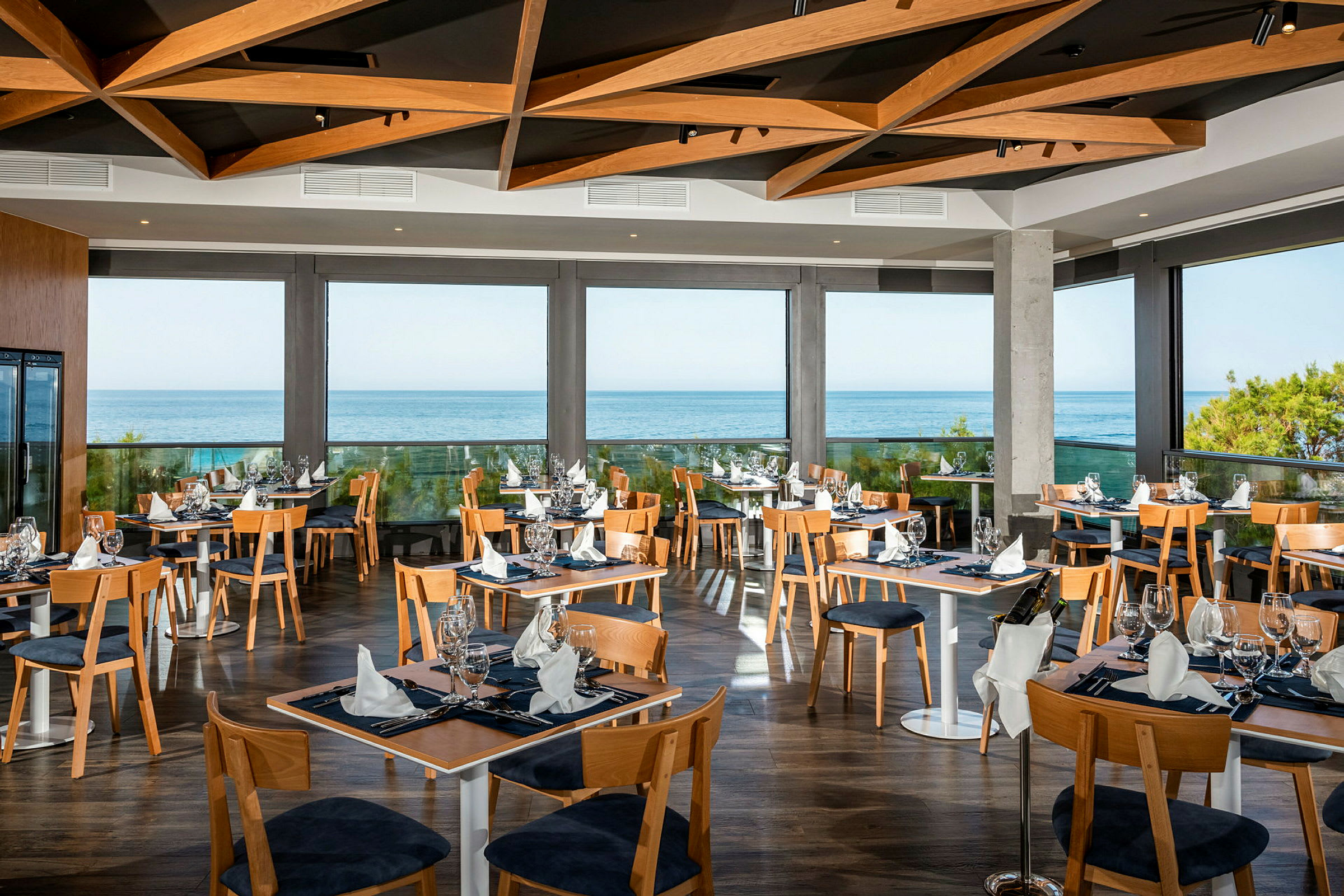 En moderne restaurant med store glasvinduer og havudsigt. (AI-genereret tekst)