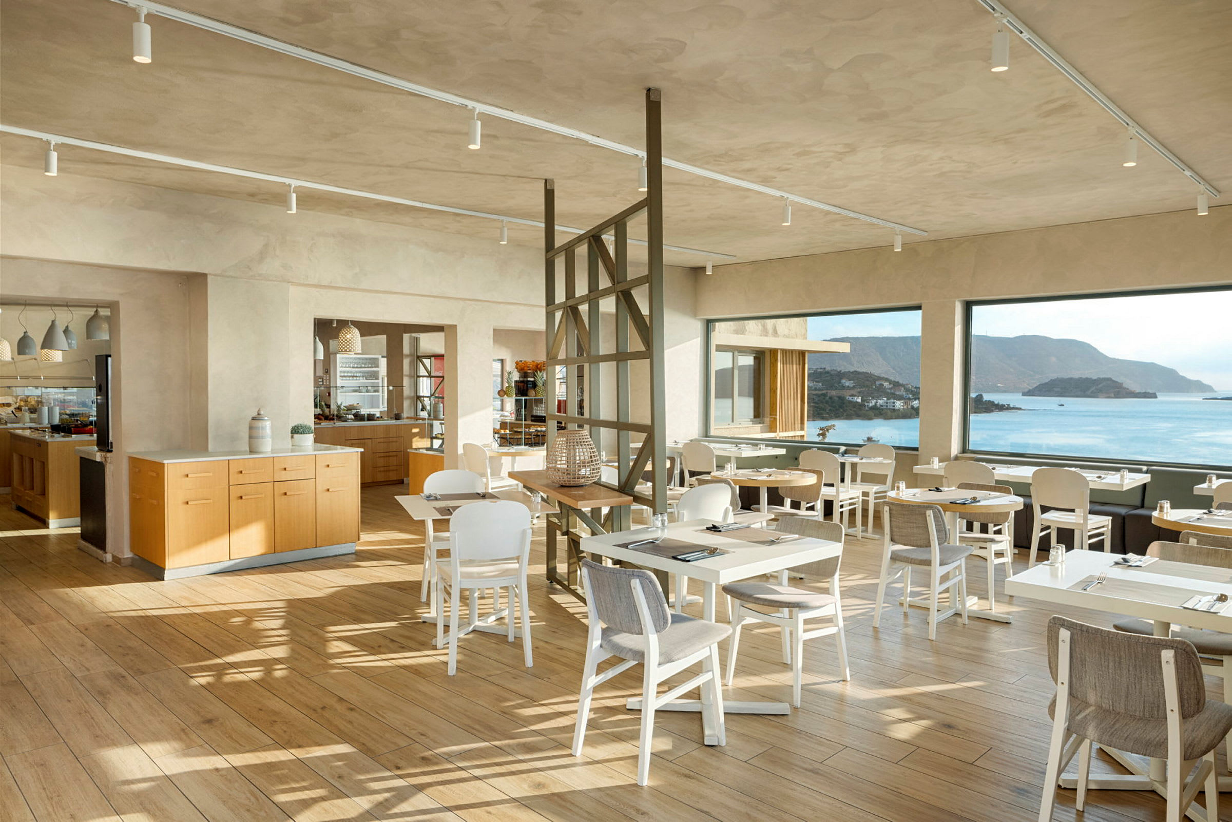 Moderne restaurantområde med store panoramavinduer og havudsigt. (AI-genereret tekst)