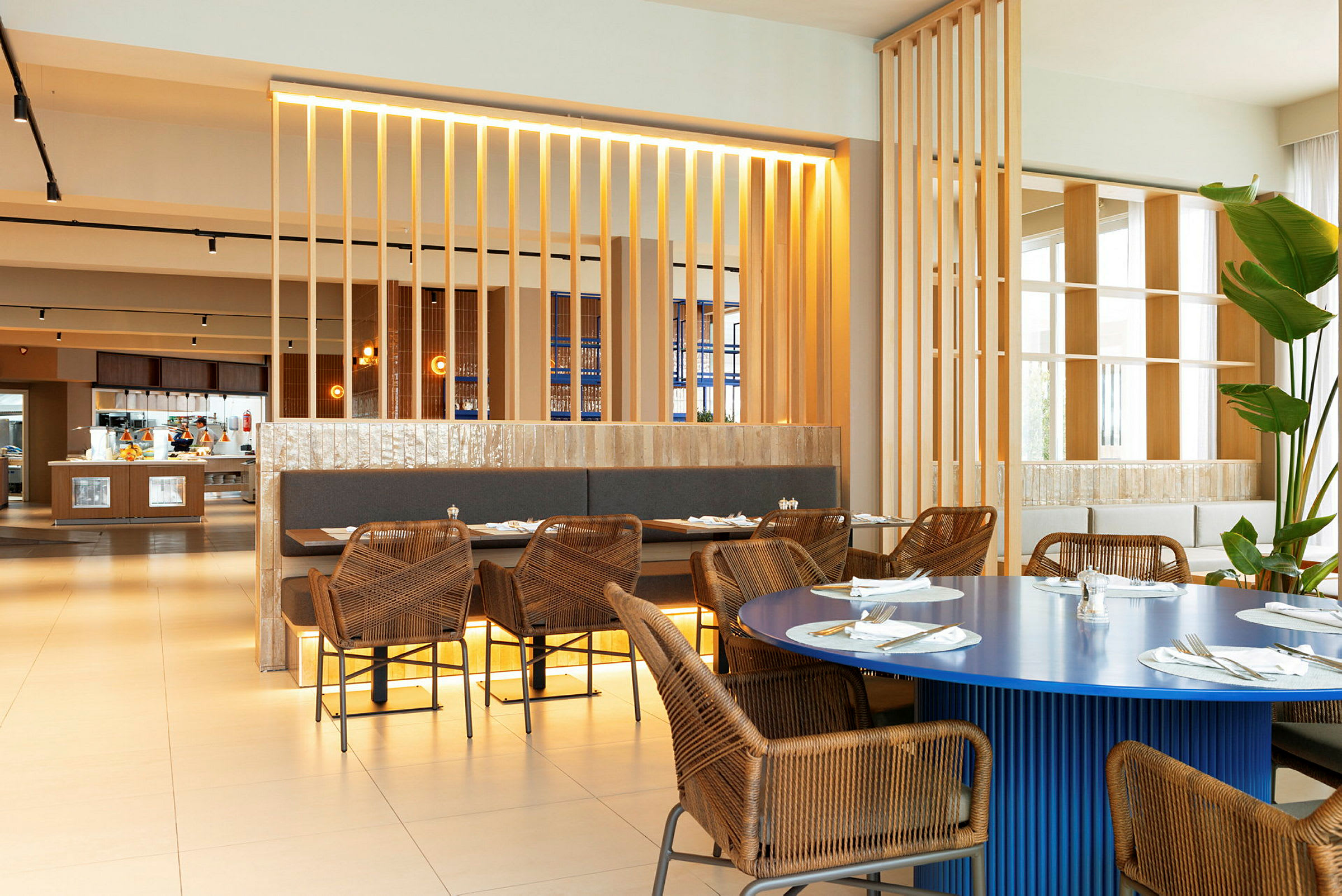 Interiør af en restaurant med rottingstole og borde med duge. (AI-genereret tekst)