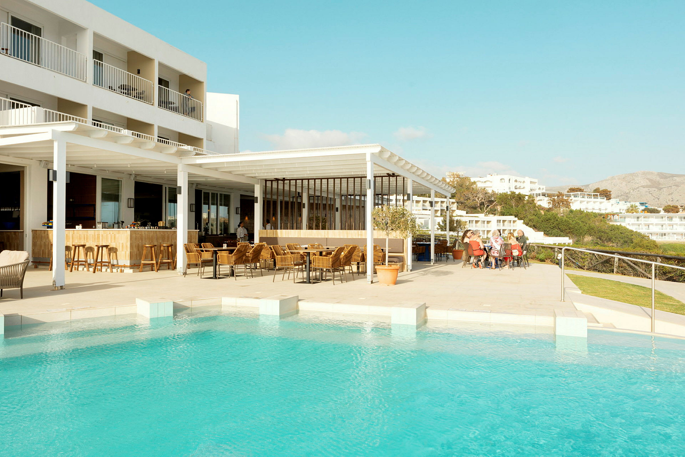 Hotelområde ved pool med udendørs servering. (AI-genereret tekst)
