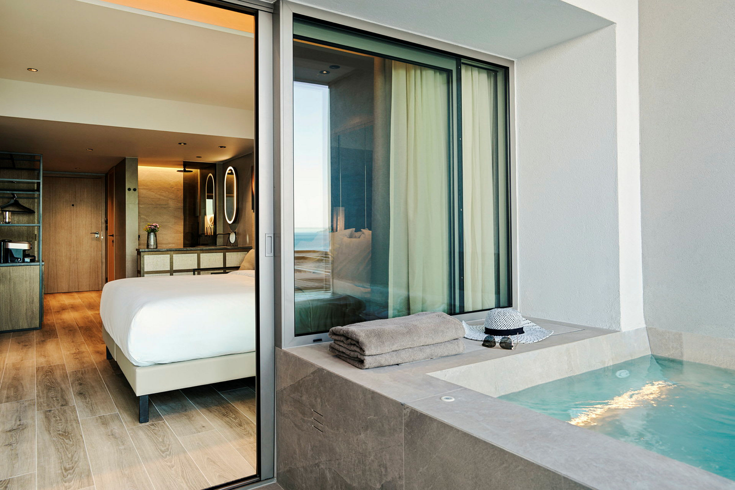 En hotelsuite med et soveværelse og en udendørs jacuzzi. (AI-genereret tekst)
